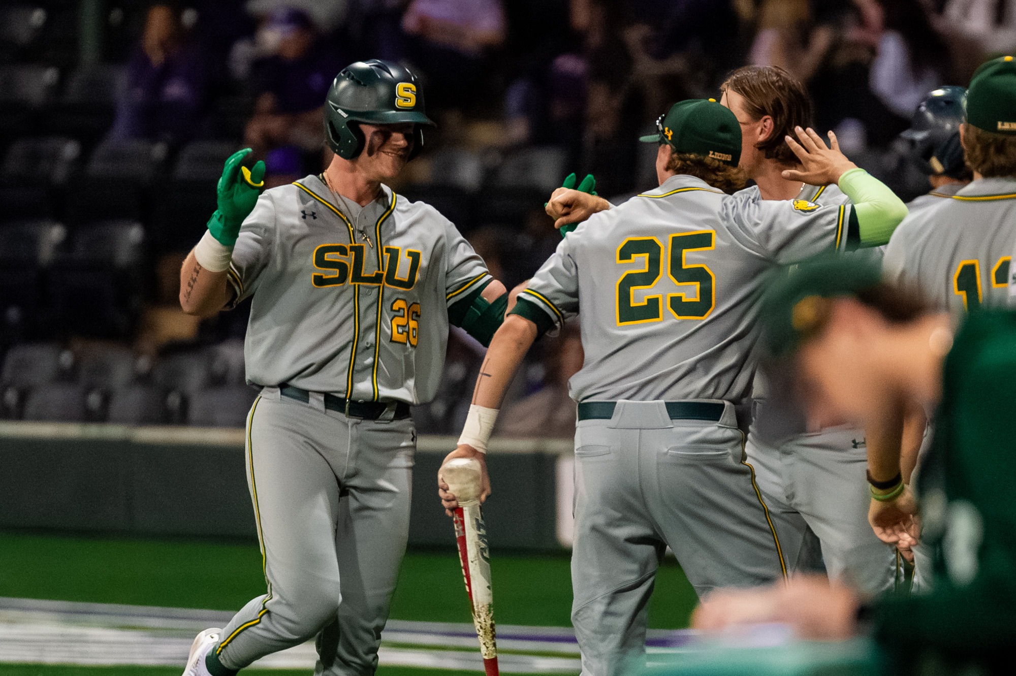 Blaise Priester receives congratulation from his teammates upon returning to the dugout following a sacrifice bunt.