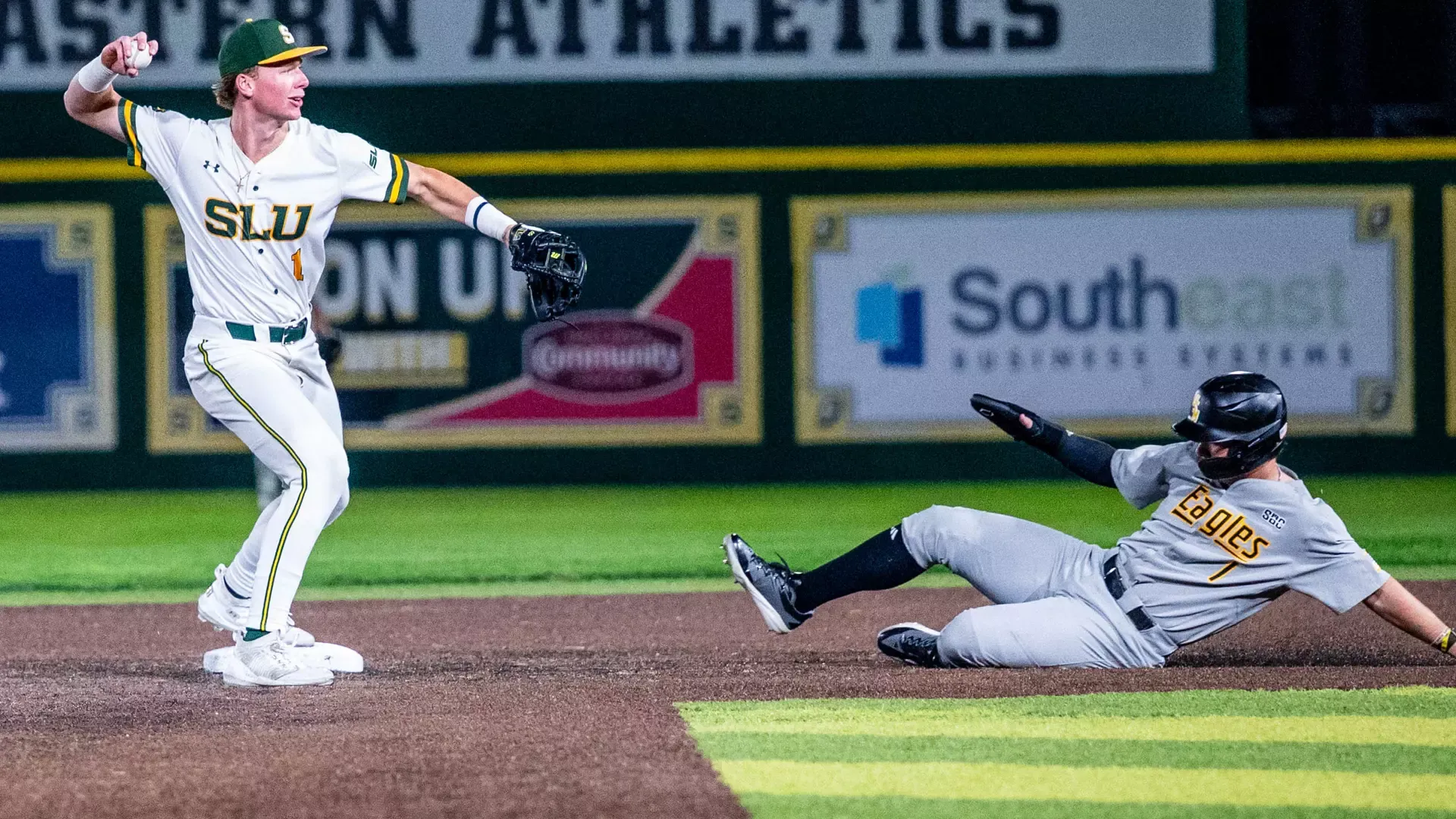 Connor Cuff fires the ball to first base to complete a double play as a Southern Miss runner slides into second base.