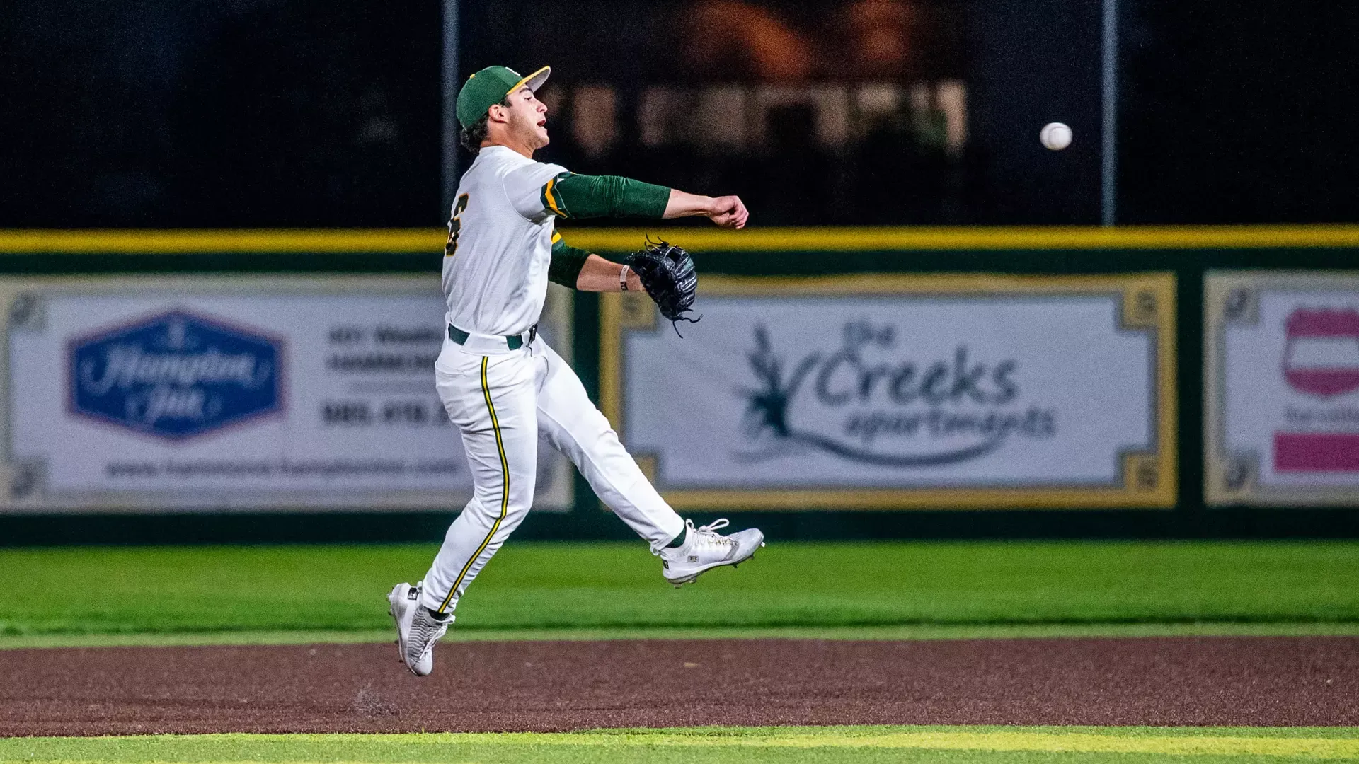 Ben Robichaux leaps into the air and fires the ball across his body to first base.