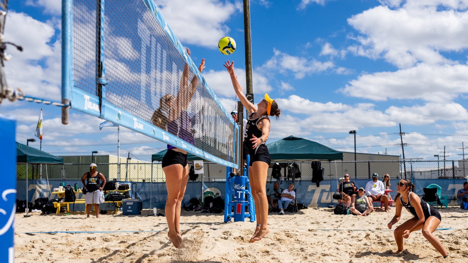 Mia McKinney over the net in Tulane Beach Duals