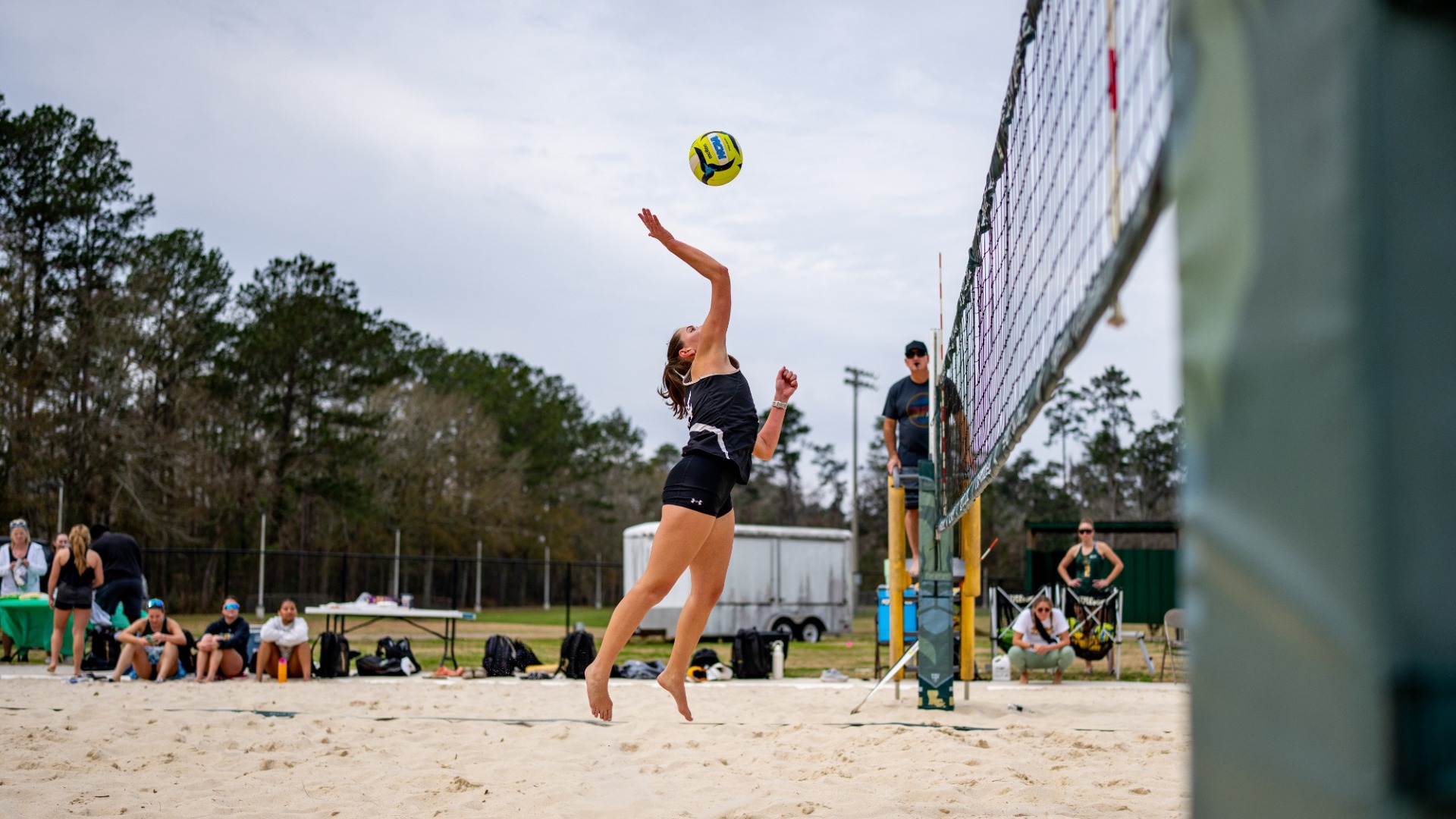 Mia McKinney hitting the ball over the net in the team's Green vs Gold match