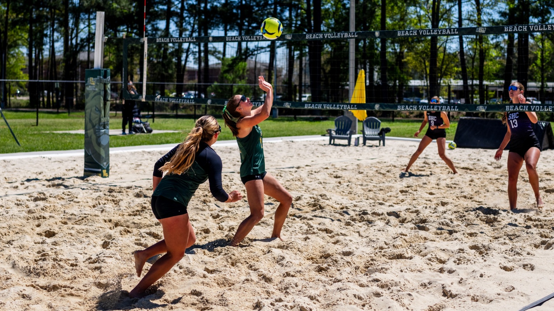 Elizabeth Hardouin setting for pair five partner Genevieve Schubert to spike the ball vs Spring Hill defender
