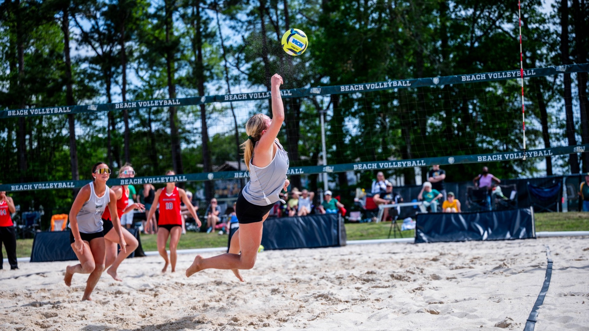 Taylor Stockwell diving in the sand for a dig to recover a spike vs William Carey defender