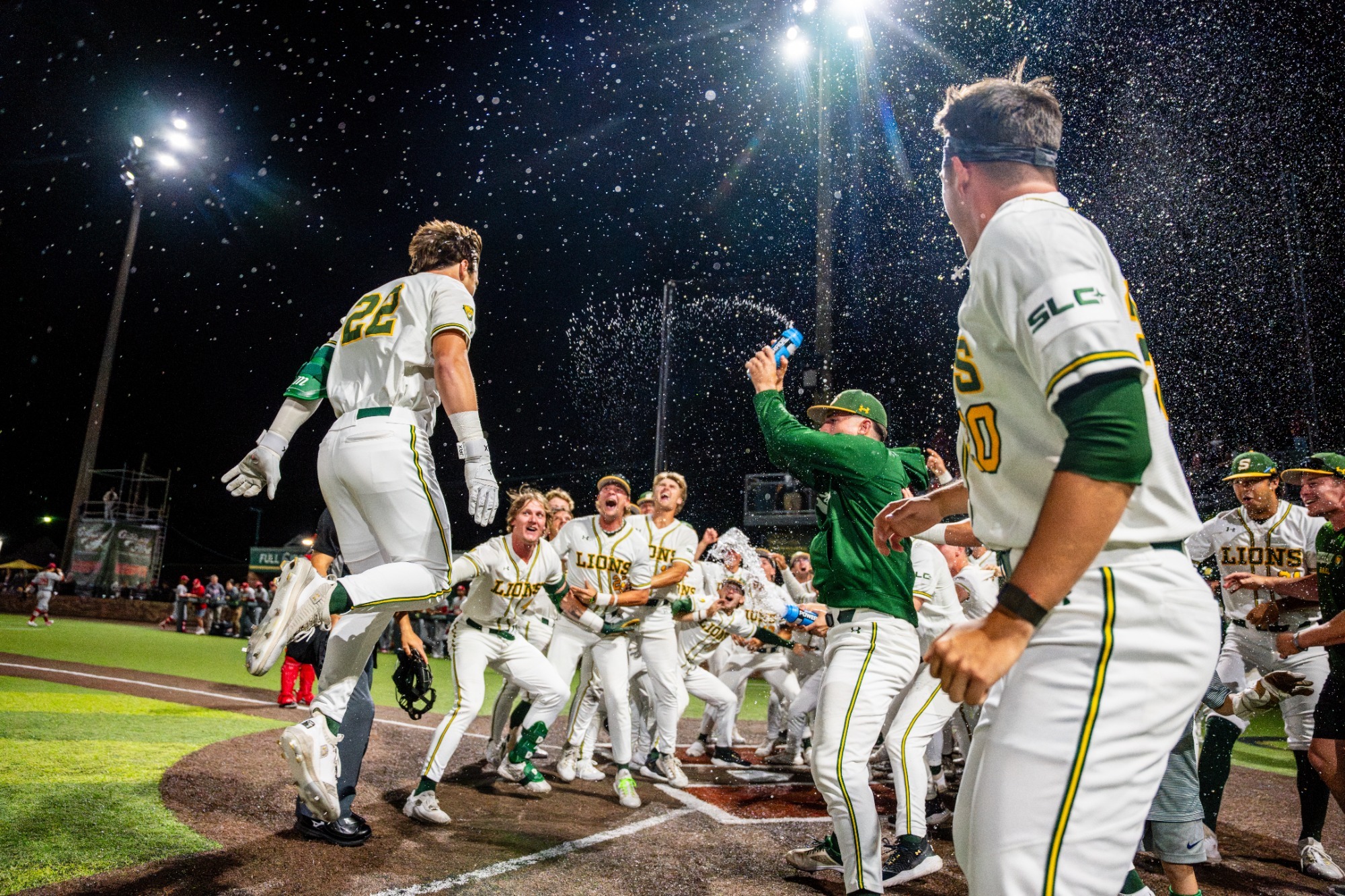 Rhett Centanni gets sprayed with water by his teammate as he leaps toward home plate following his walk-off home run against the Ragin' Cajuns.