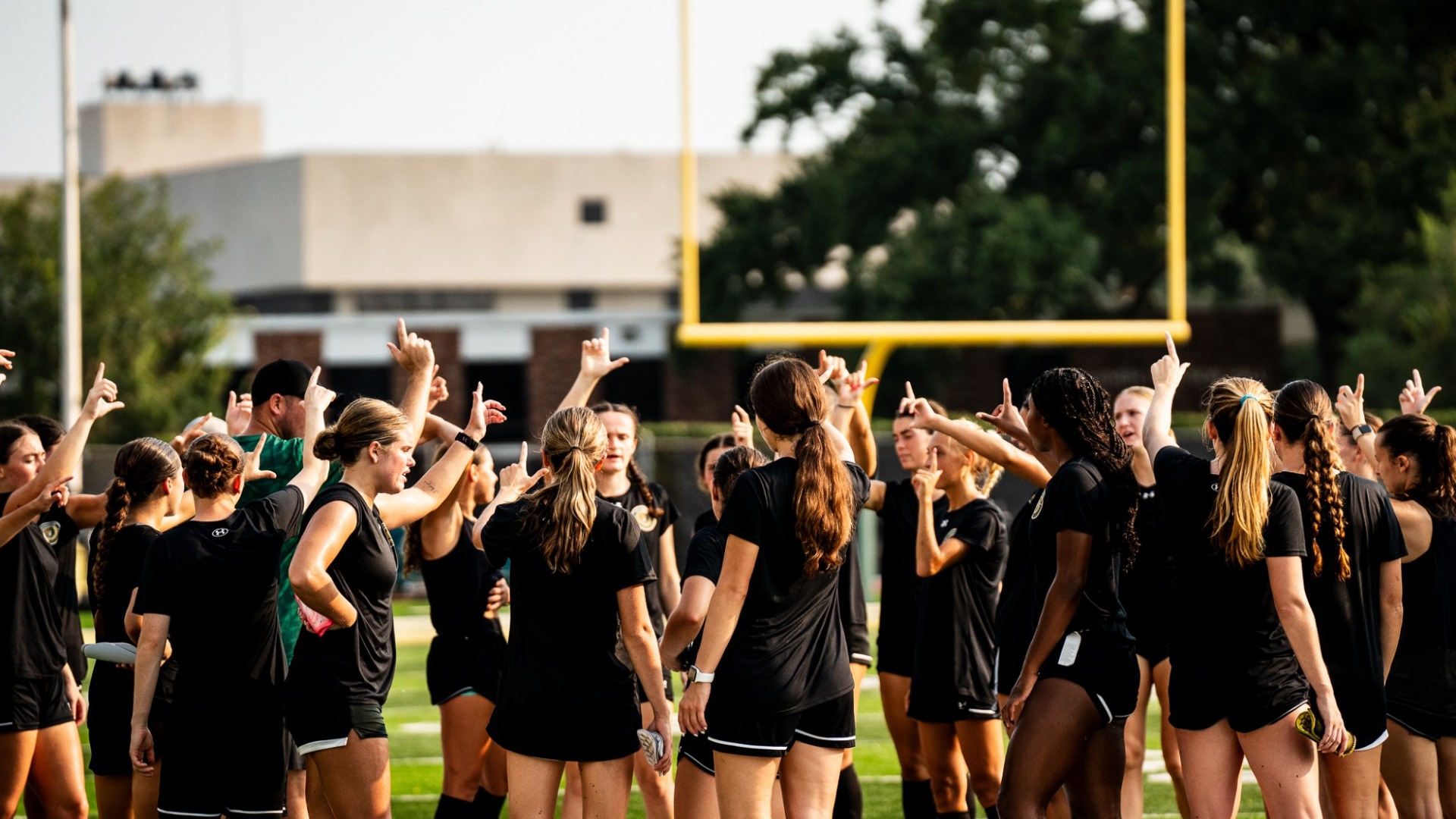 Southeastern women's soccer team huddle as players signal Lion Up at the end of preseason practice out on the field in Strawberry Stadium