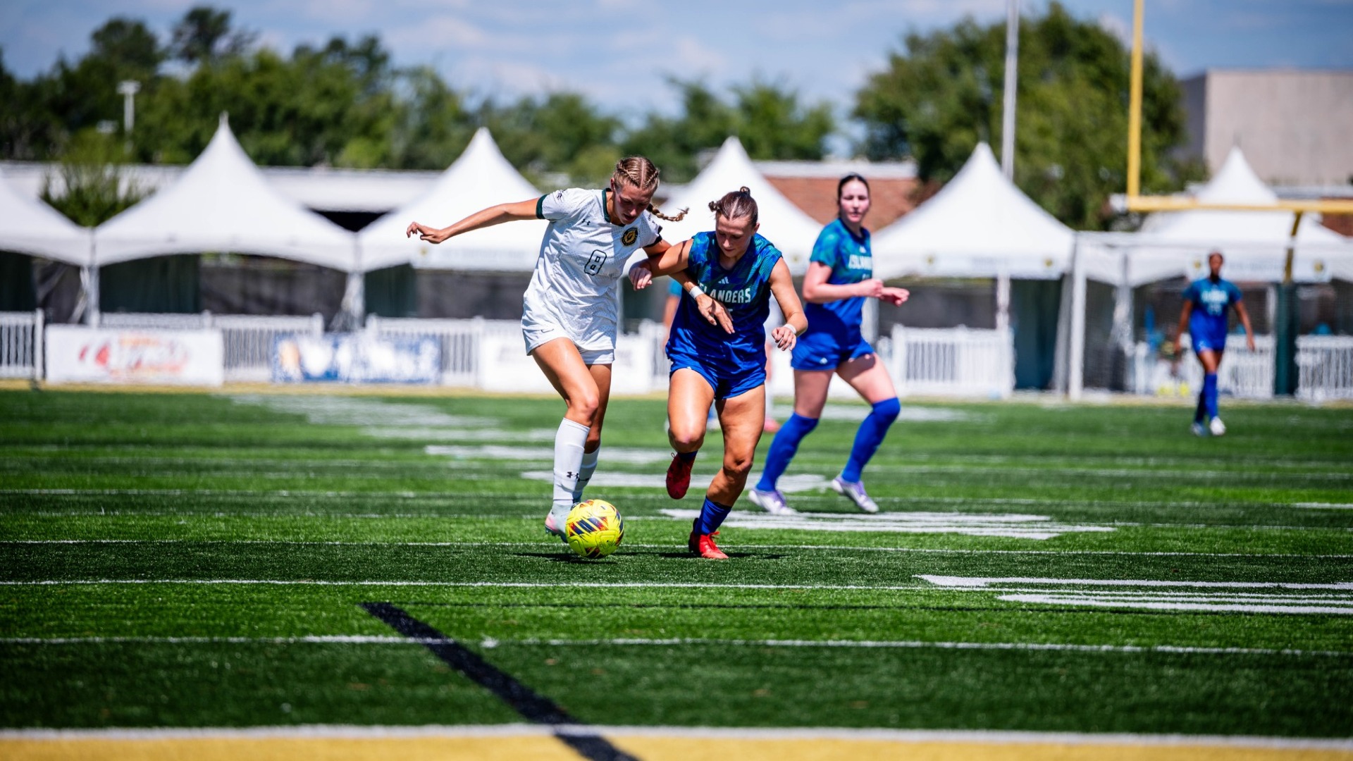 Women's soccer player Brooke Opferman fighting for control of ball vs Islanders' defender