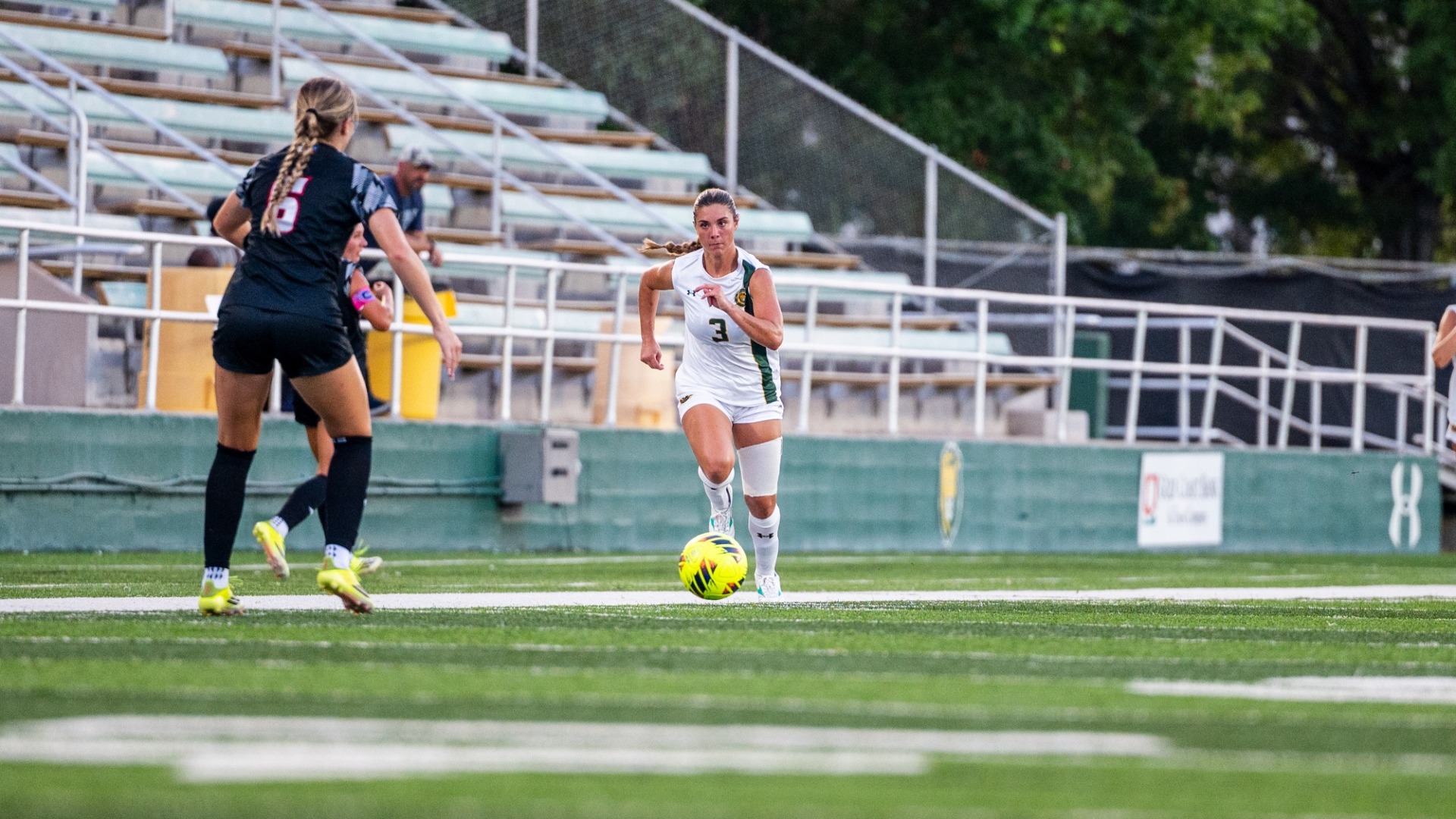Women's soccer player Charlotte Lewis pushing the ball up the field versus ULL defender