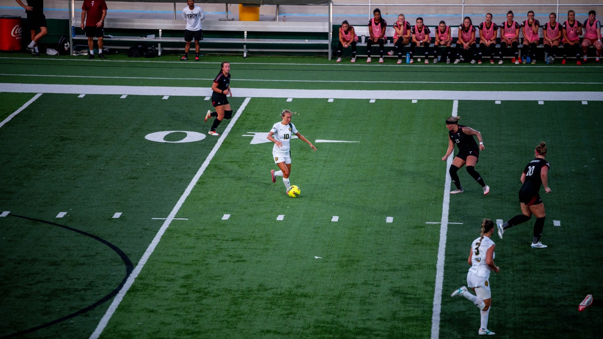 Women's soccer player Kaitlyn Tung working the ball up the field at home vs Troy defenders 