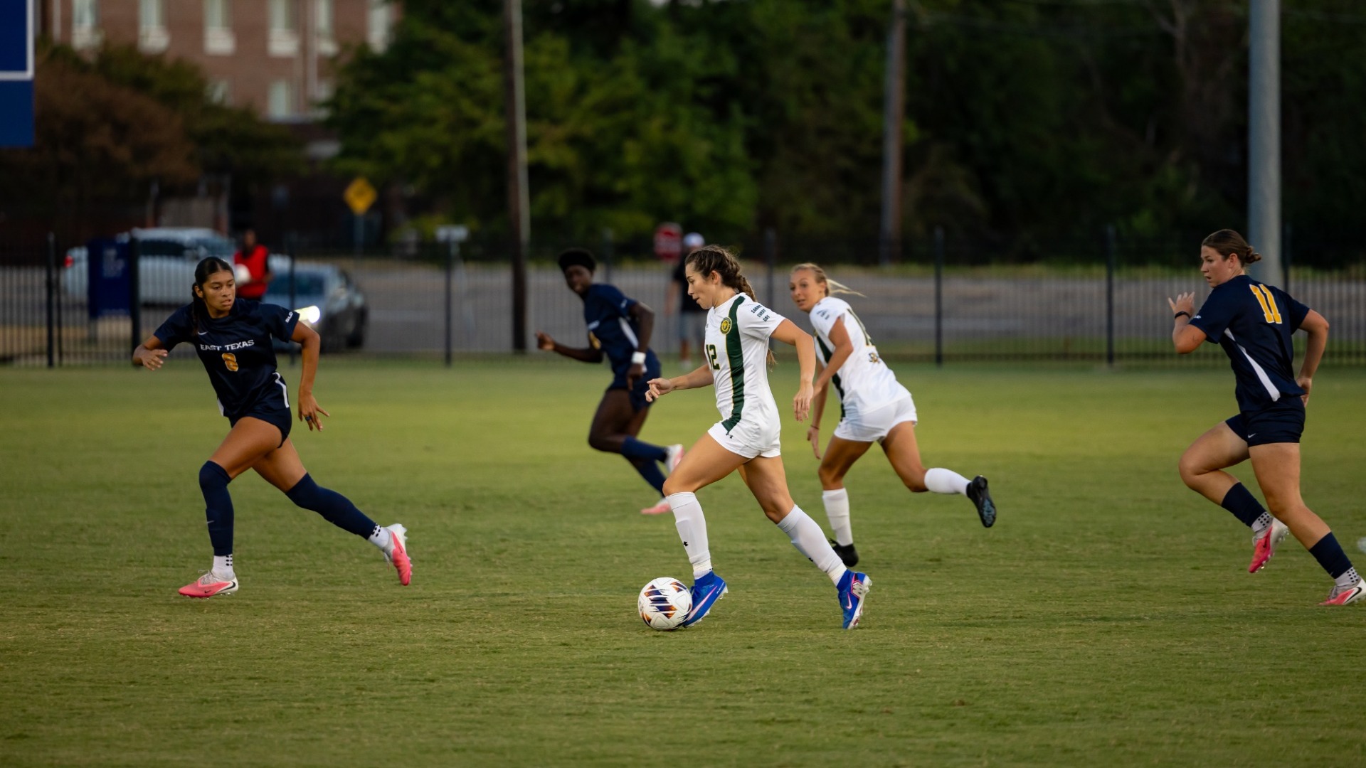 Loegan Alia looking to push past East Texas A&M defenders alongside teammate Kaitlyn Tung running up the field