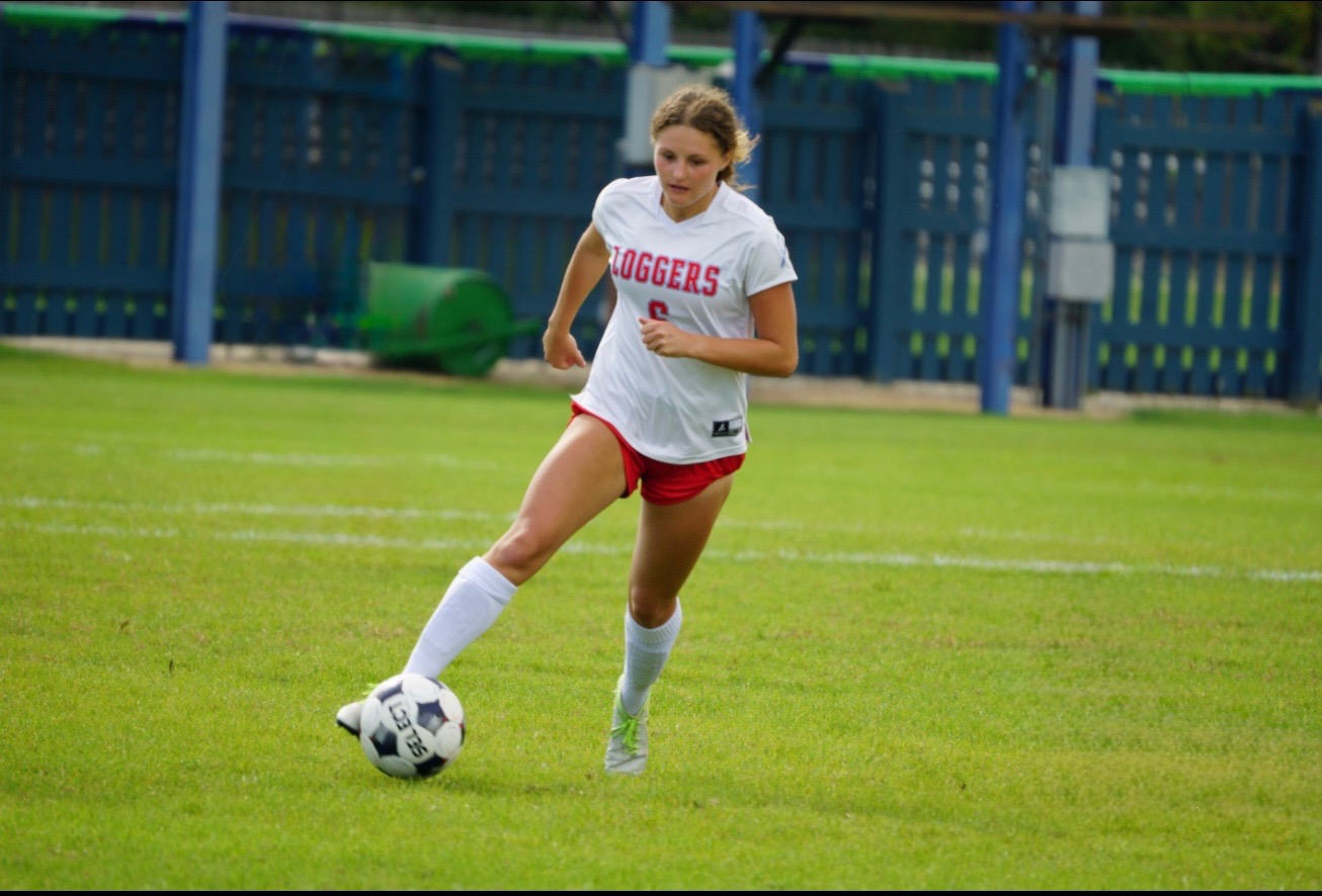 LLCC women's soccer player kicking the ball.