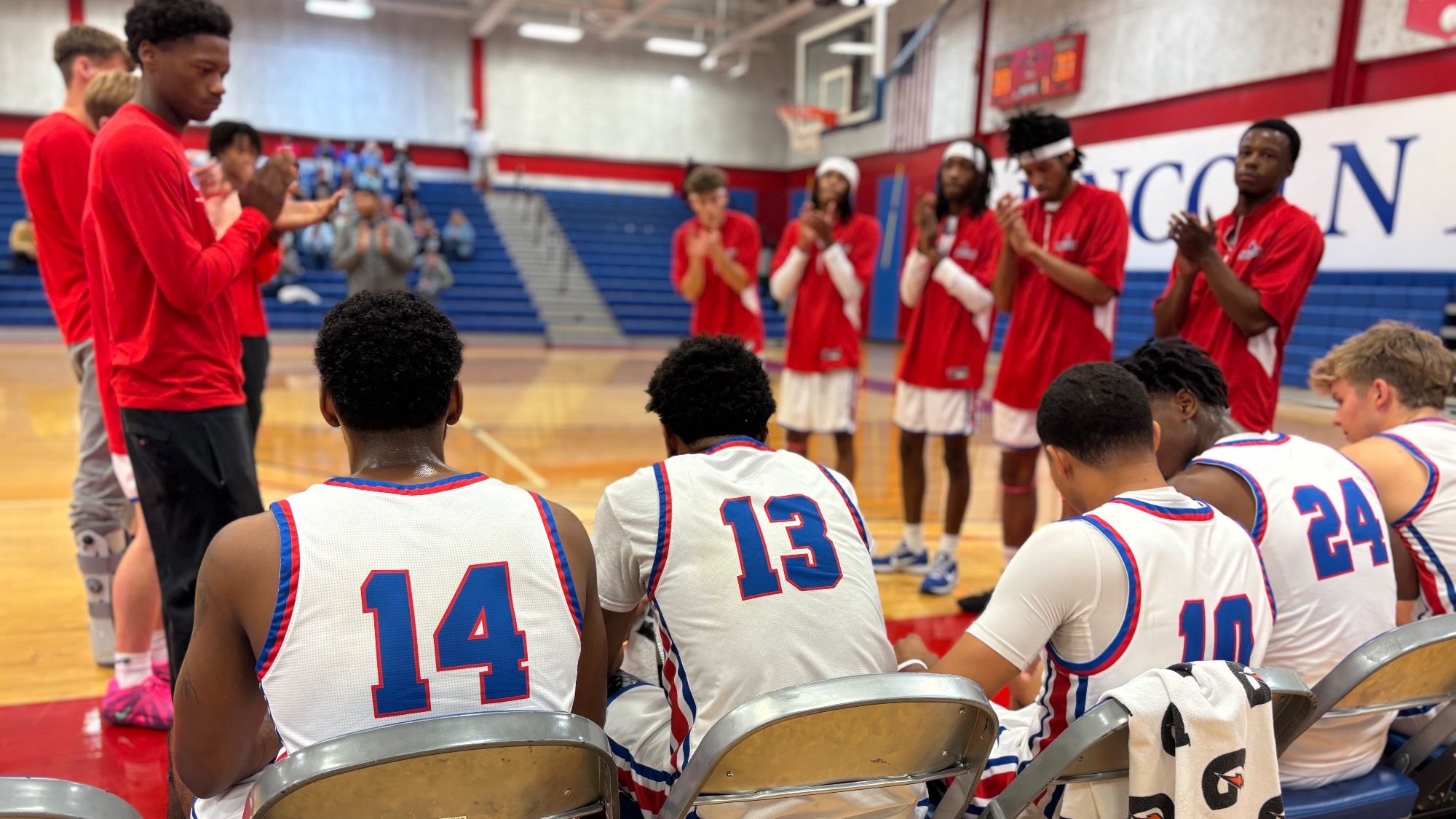 LLCC men's basketball team sitting on the bench.