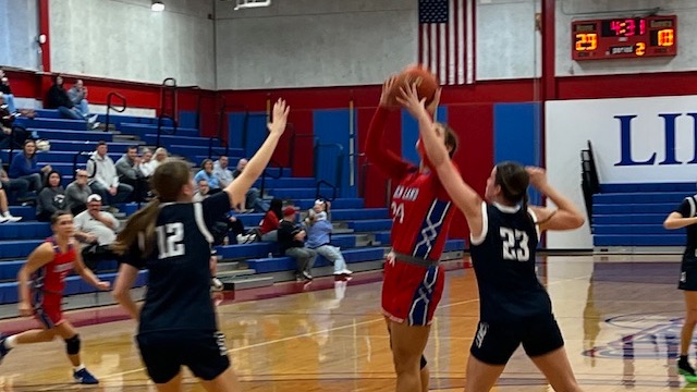 LLCC women's basketball team playing basketball.