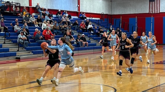 LLCC women's basketball players playing basketball.