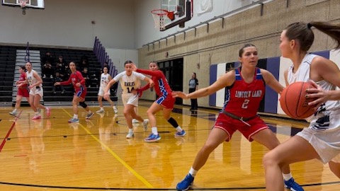 LLCC women's basketball team playing basketball.