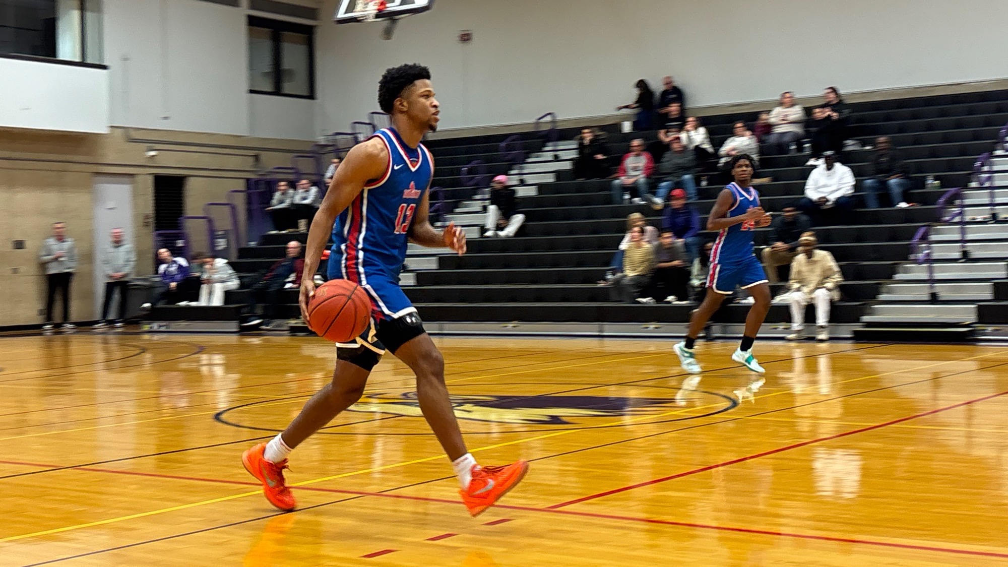 LLCC men's basketball player drilling a basketball.