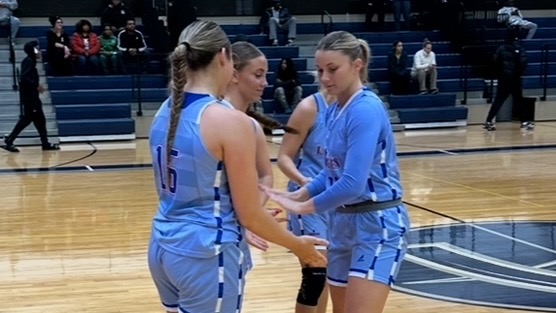 LLCC women's basketball team standing in a circle.