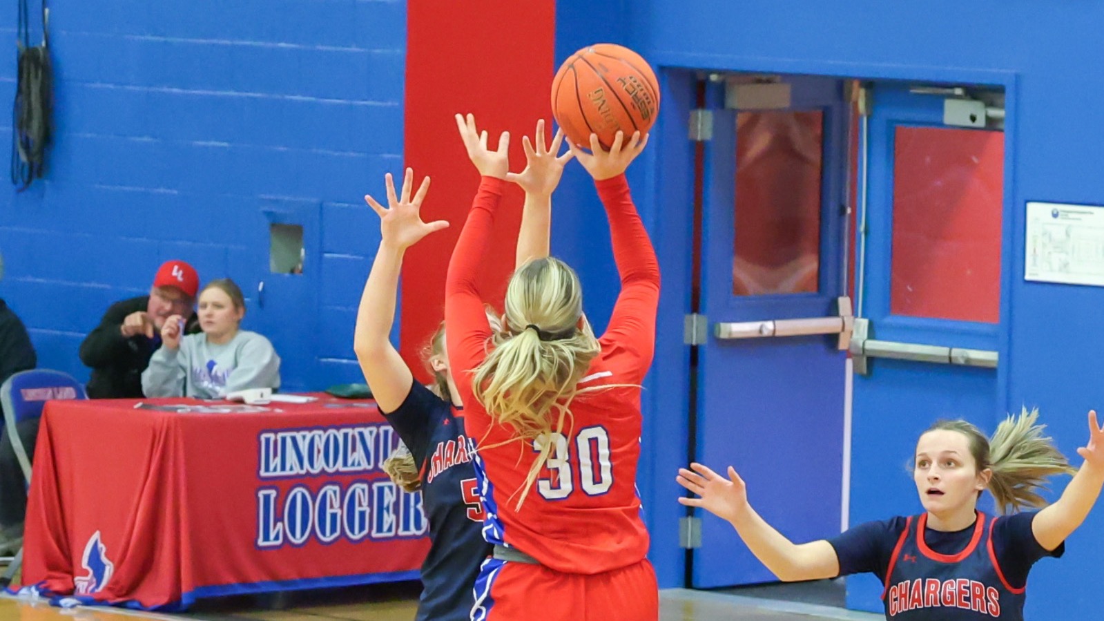 LLCC women's basketball player shooting a basketball.
