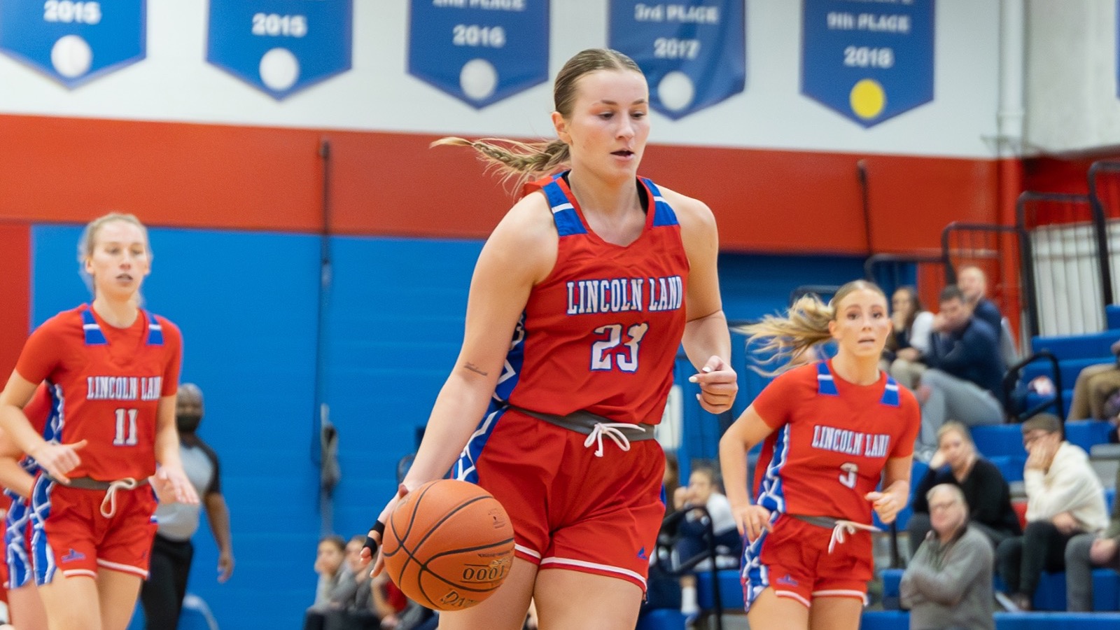 LLCC women's basketball player dribbling a basketball.