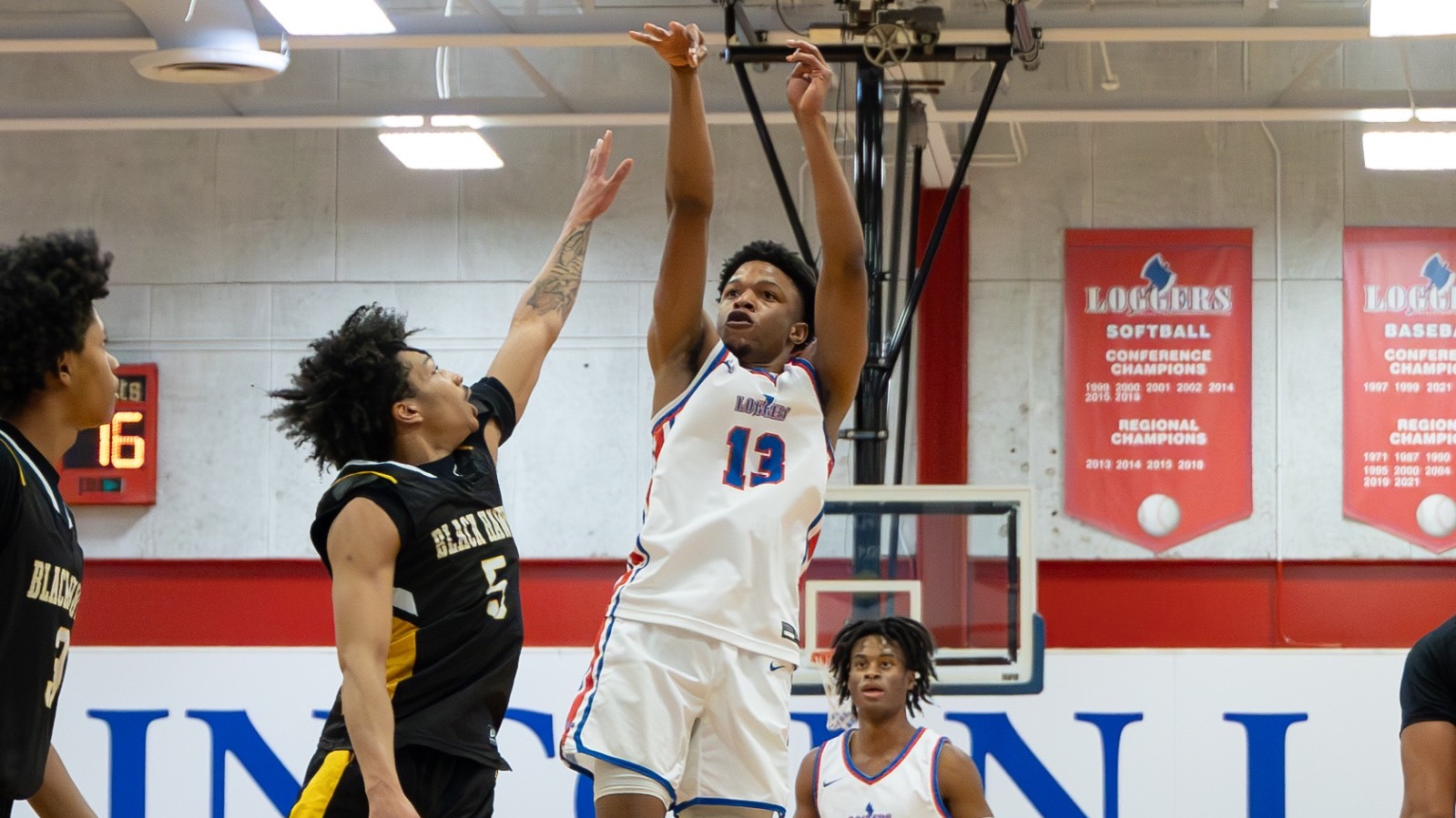LLCC men's basketball player shooting a basketball.