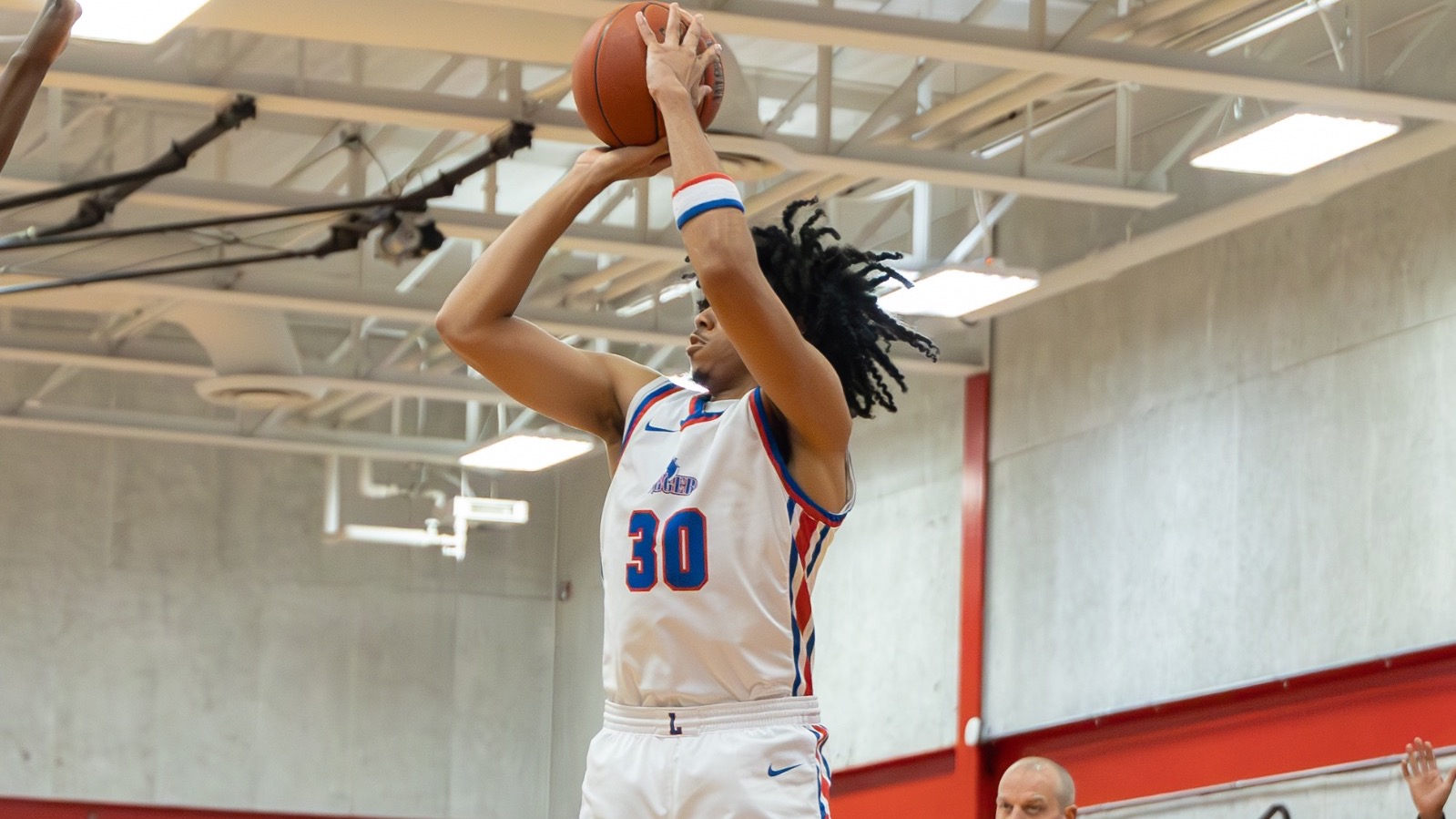LLCC men's basketball player shooting a basketball.
