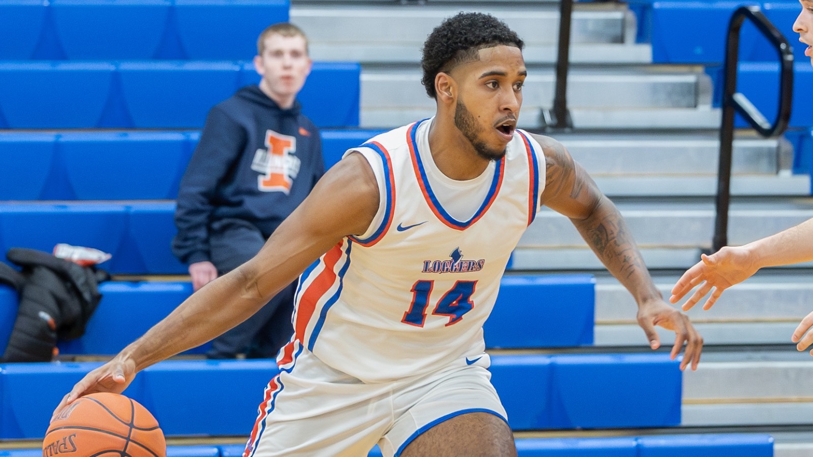 LLCC men's basketball player dribbling a basketball.