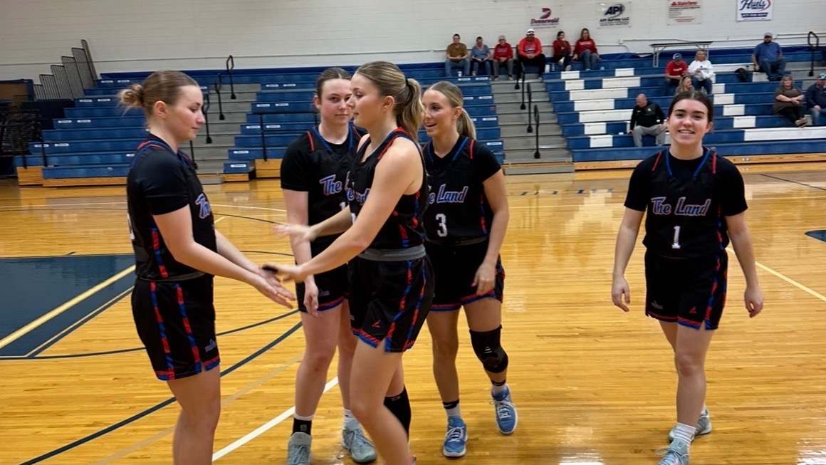 LLCC women's basketball team standing around.