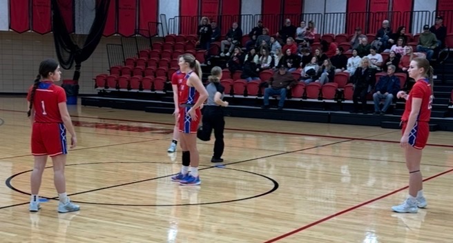 LLCC women's basketball team playing basketball.