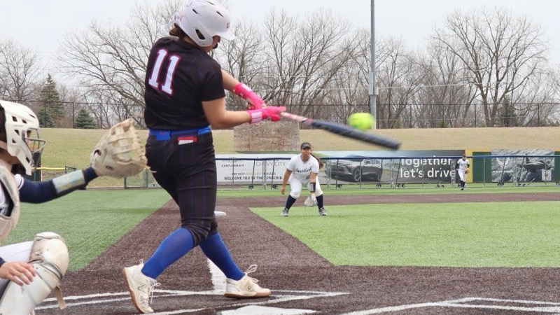 LLCC softball team hitting a softball.