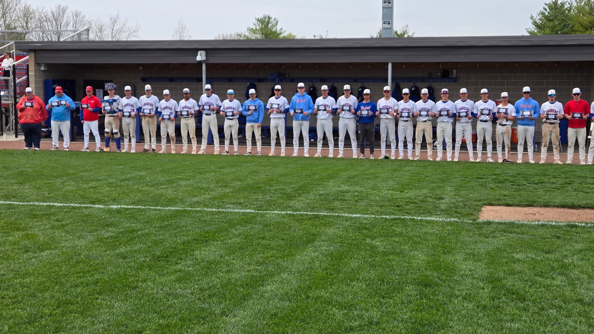 LLCC baseball team standing holding signs.