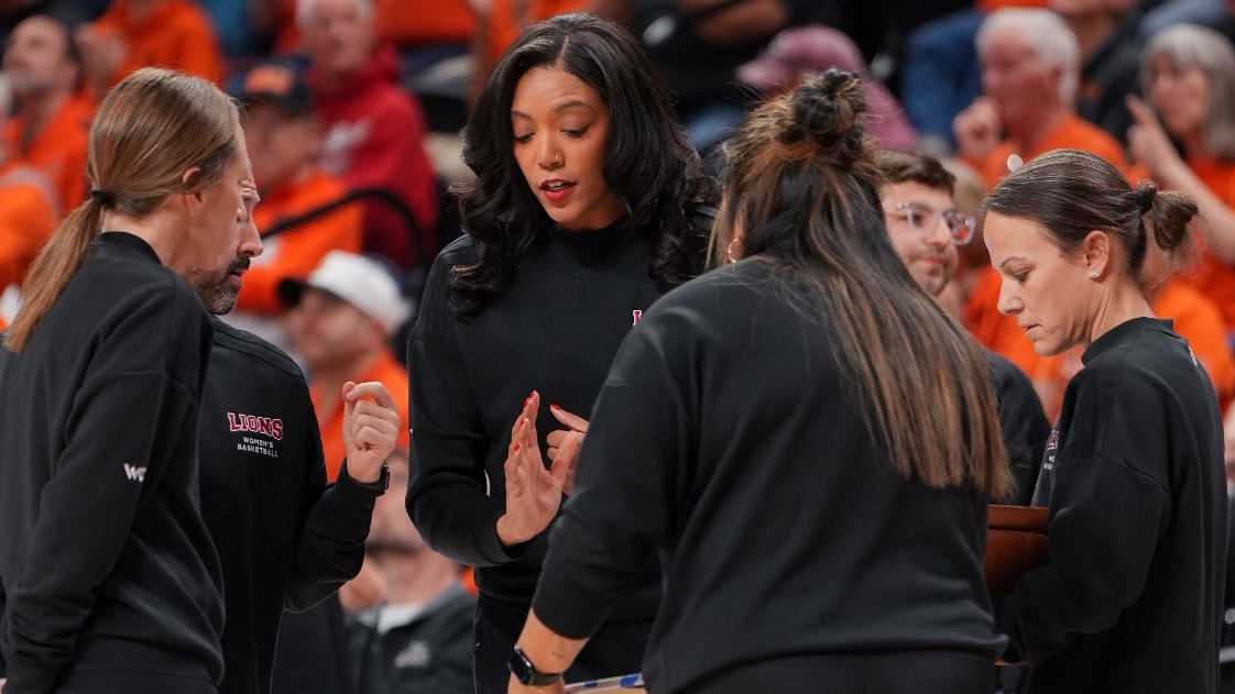 Coach Aarika Hughes mid huddle with coaching staff