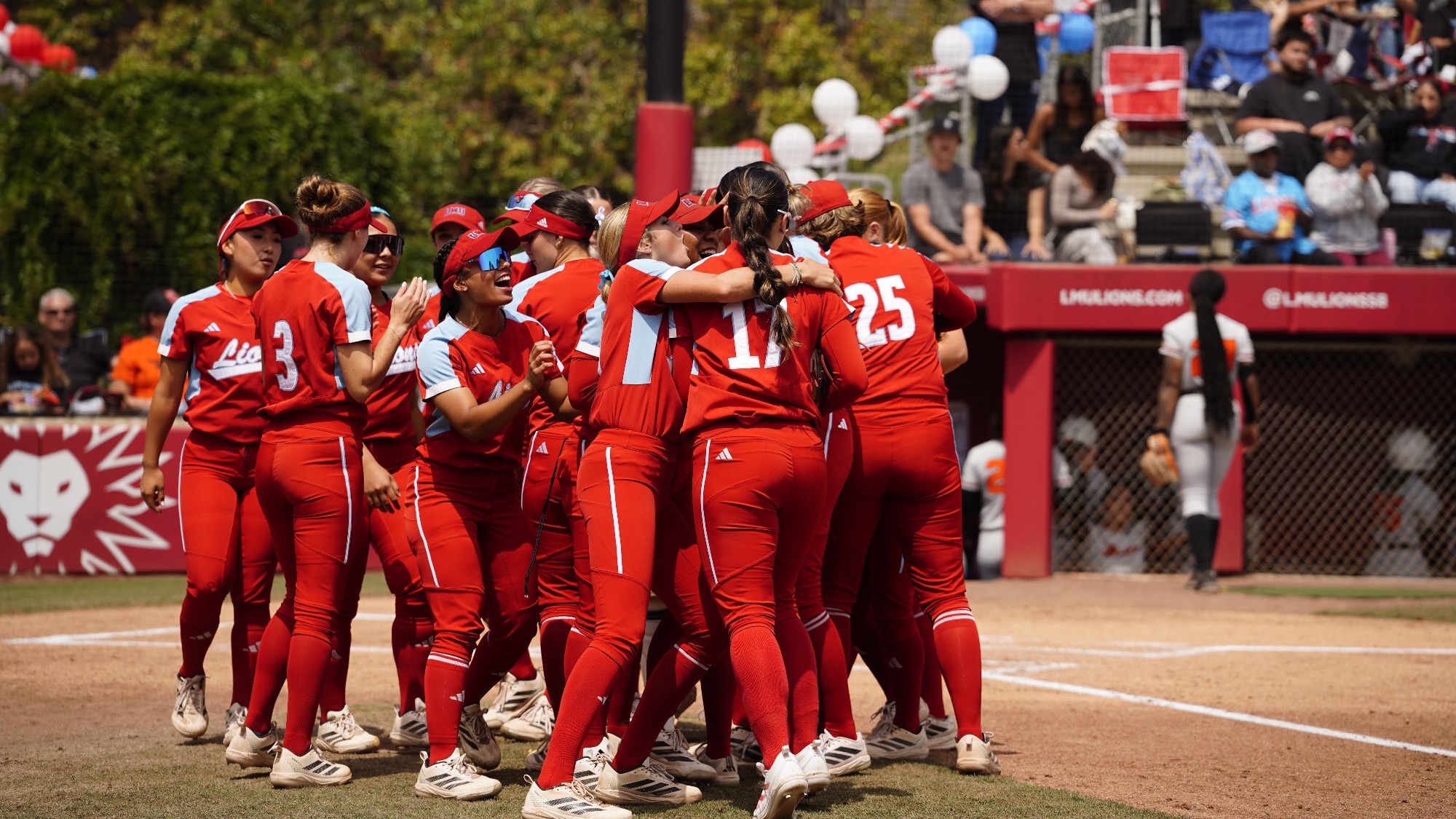 SB huddled celebrating on side of field