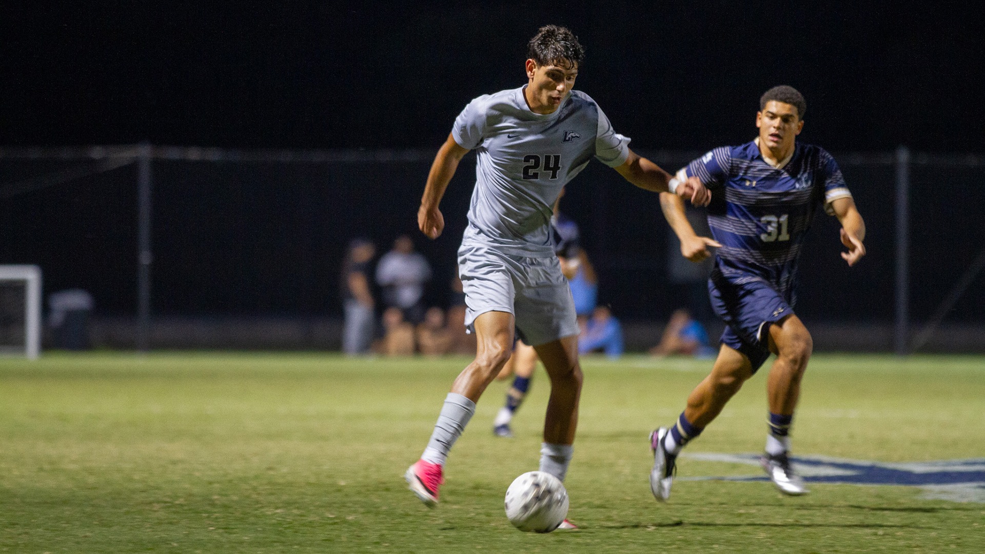 Benjamin Ferrero dribbles toward goal with a Navy defender on his back during the Tribe's home match on Sept. 15, 2026. 