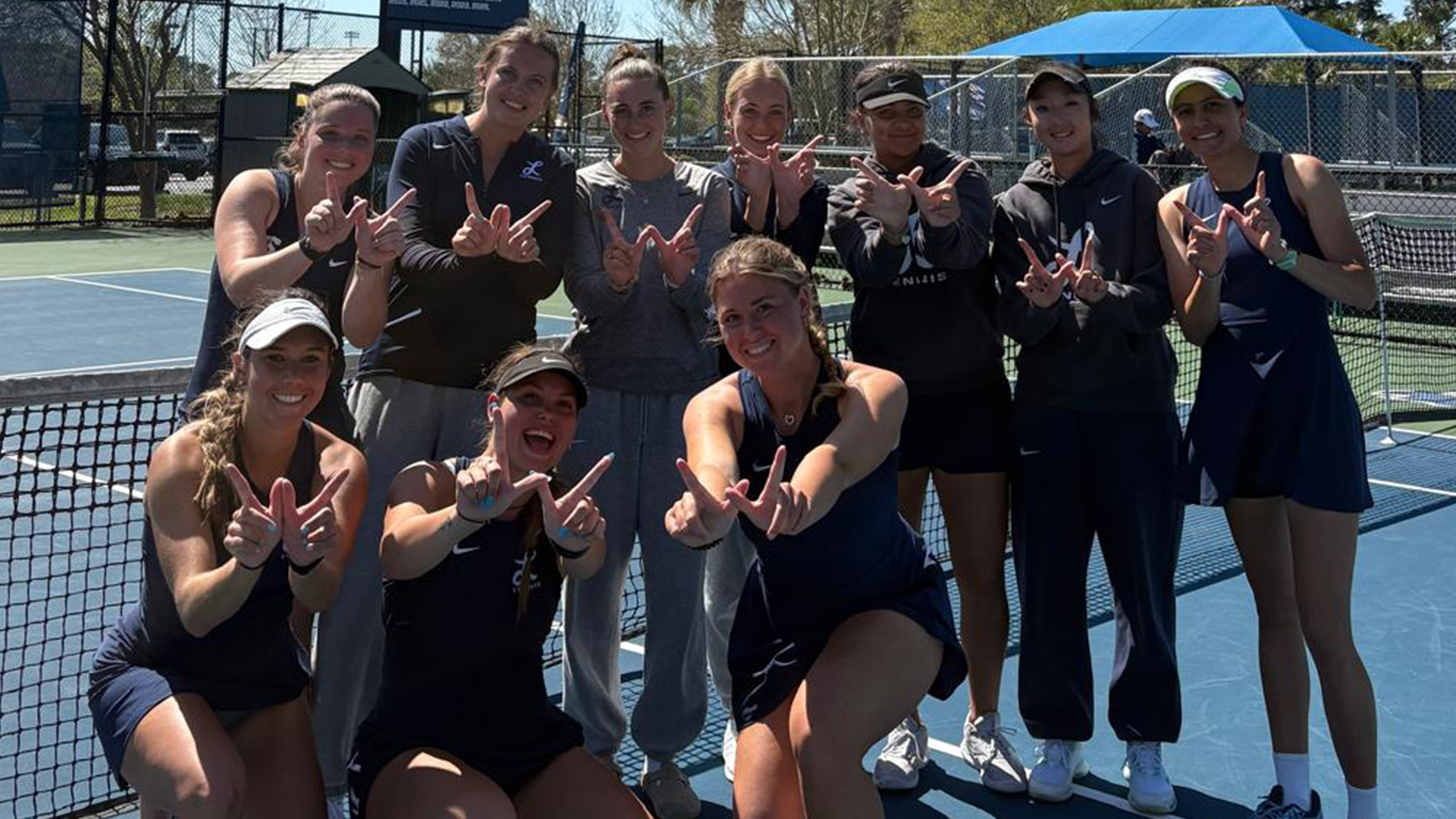 Women's tennis celebrates after beat Charleston Southern