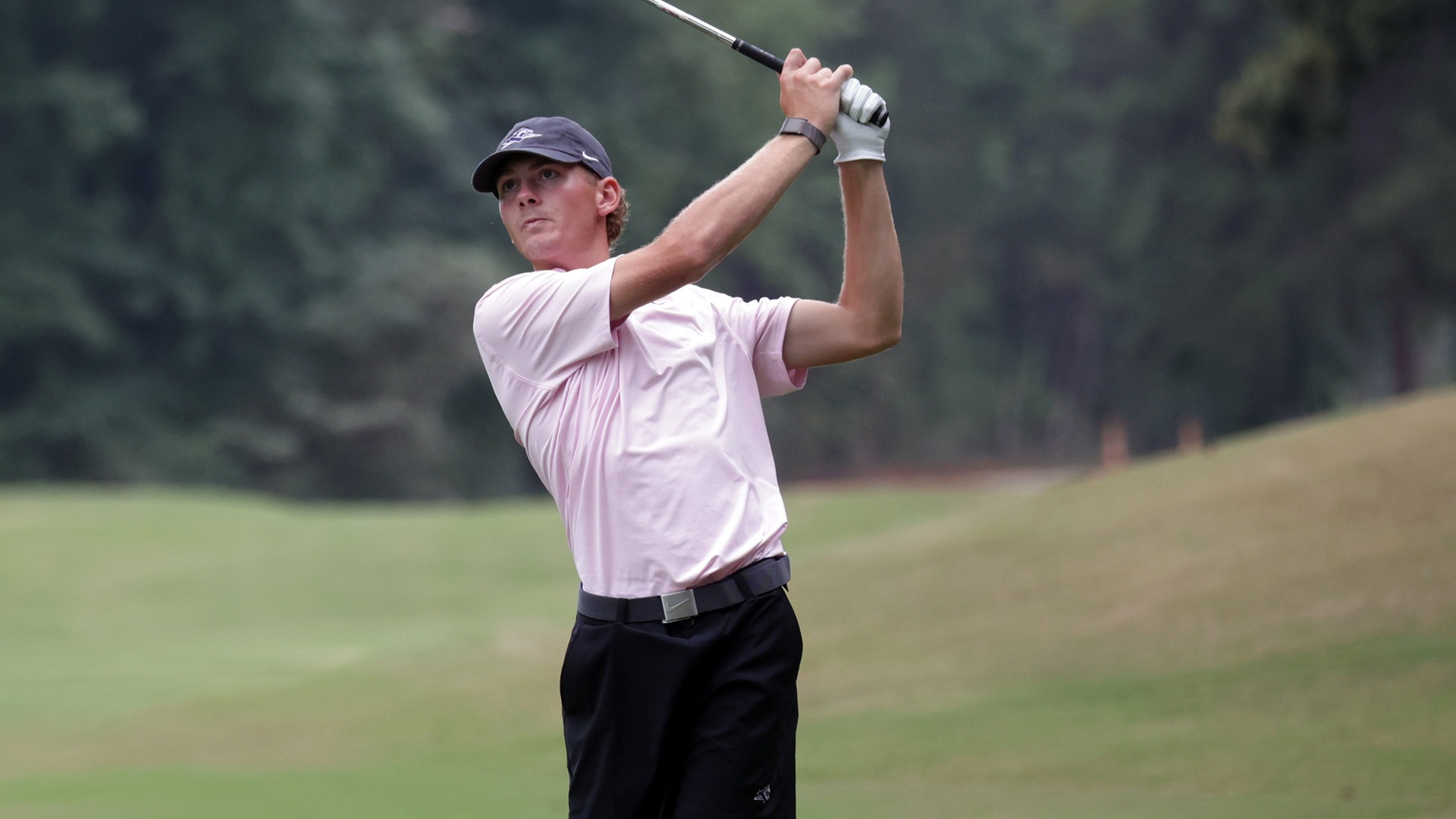 Josh Cummins follows through with an iron shot from the fairway and watches his shot during the opening round at the Bryan Collegiate Classic. 