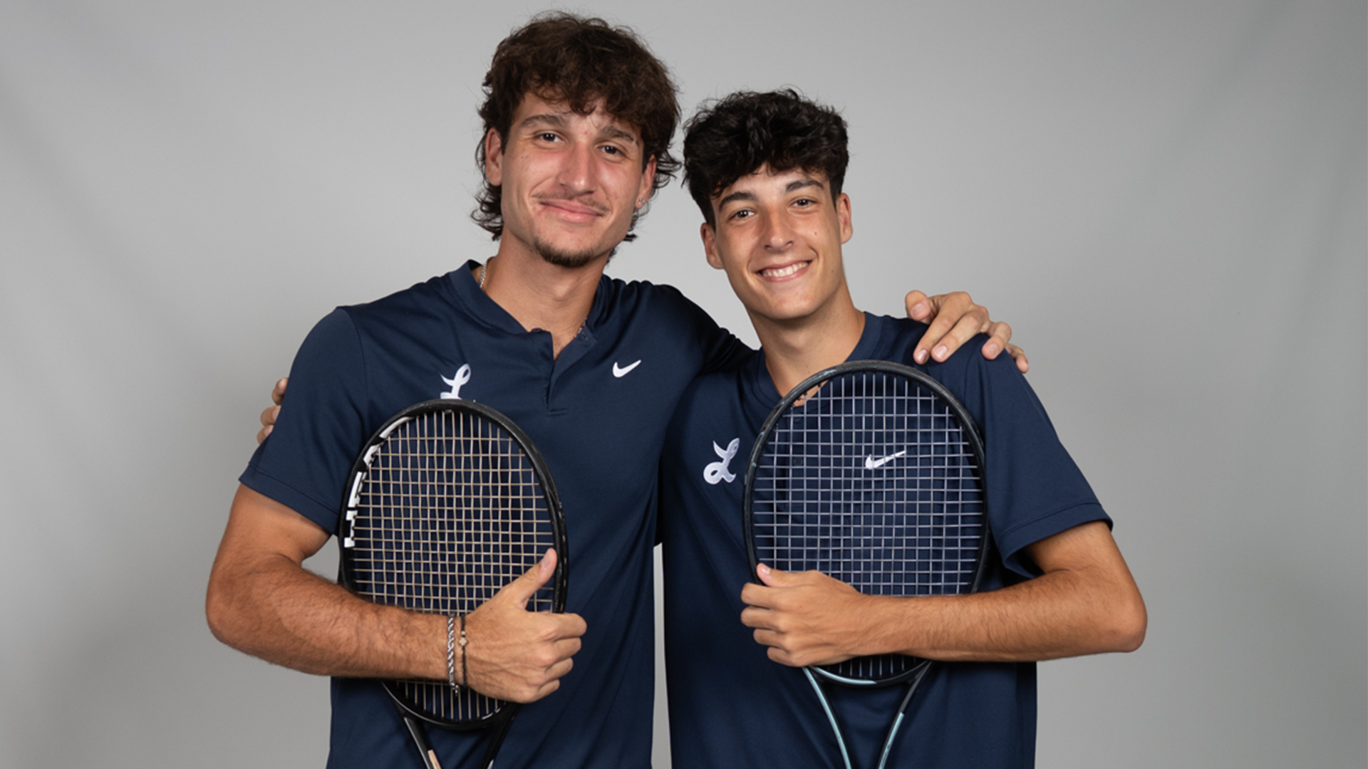 Marko Mrdak (left) and Rodrigo Guijarro pose in front of a gray backdrop with their arms around each other