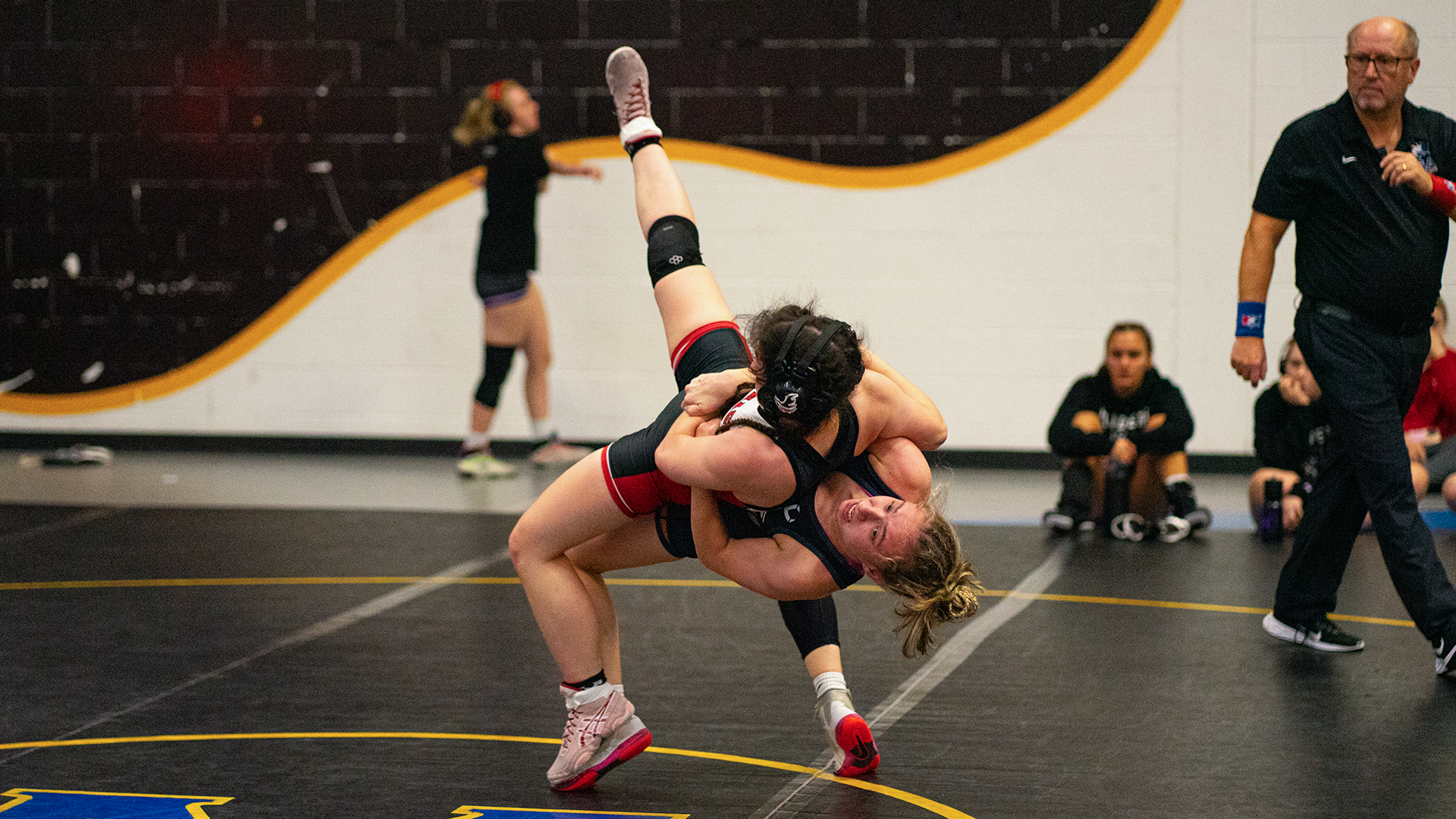 High school girls wrestler completing a throw during a match