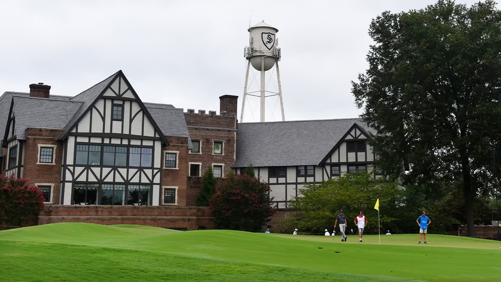 Sedgefield Country Club water tower and clubhouse with PGA Tour players in front
