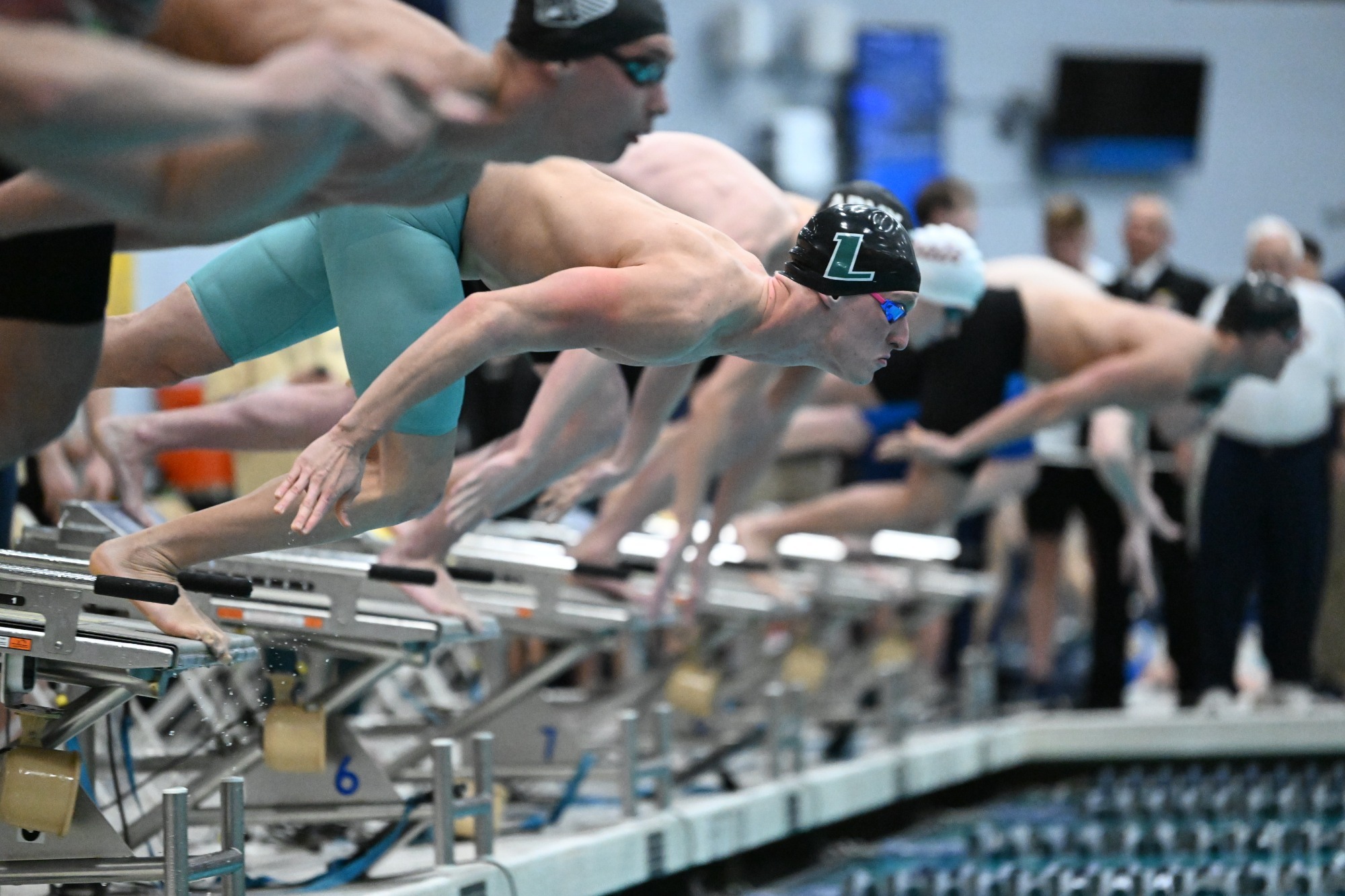 Loyola men's swimmer taking off from the blocks