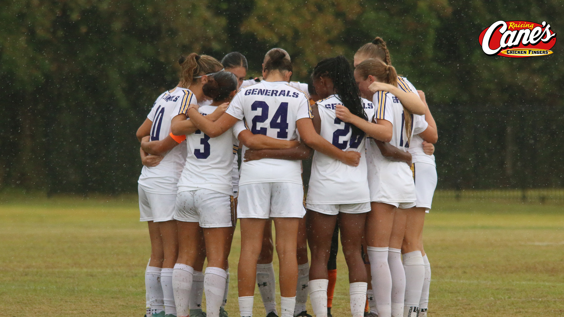 The women's soccer team huddles before kickoff