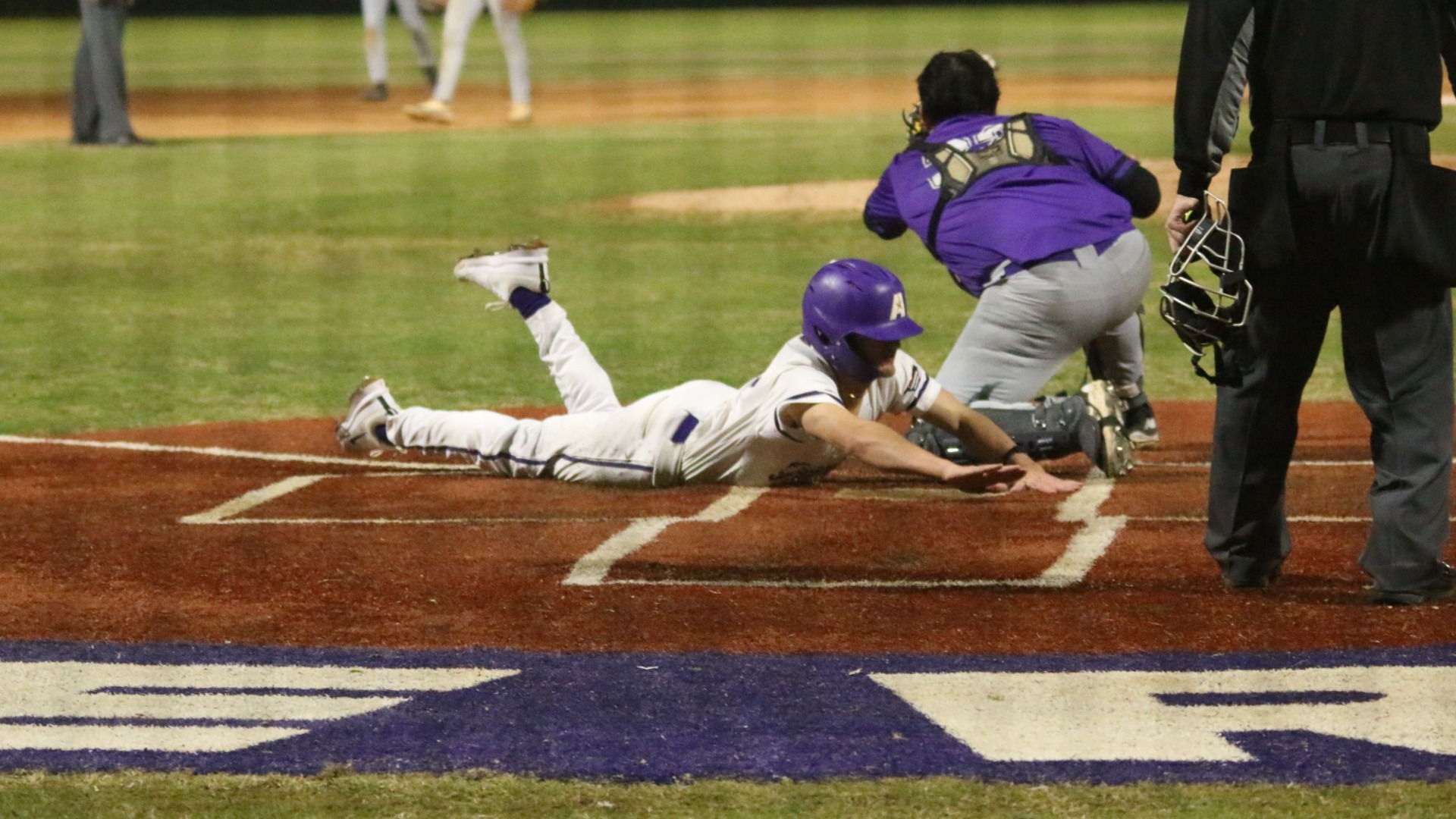 Joshua Tinnerello slides into home as the winning run against Wiley