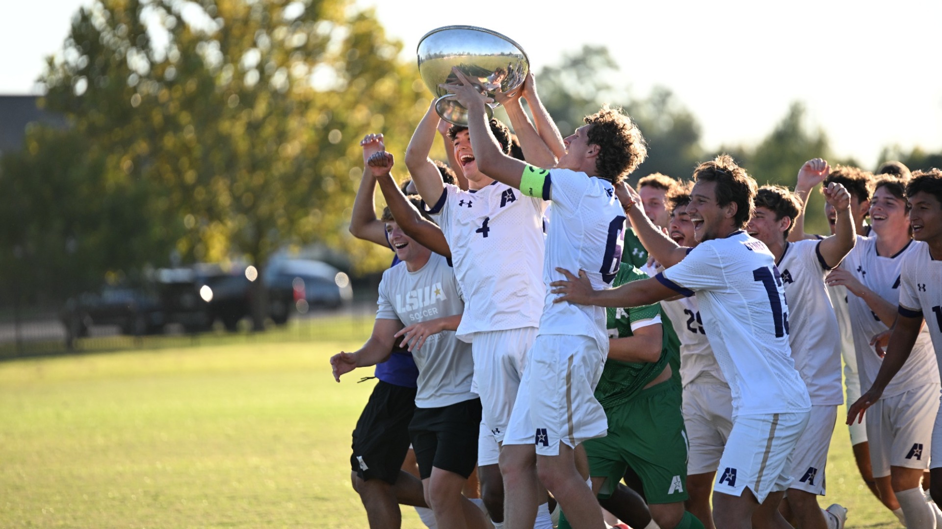 Men's Soccer team celebrates after winning the Red River Rivalry over LCU as Shay Meagher and Federico Gilardi lift the Cup