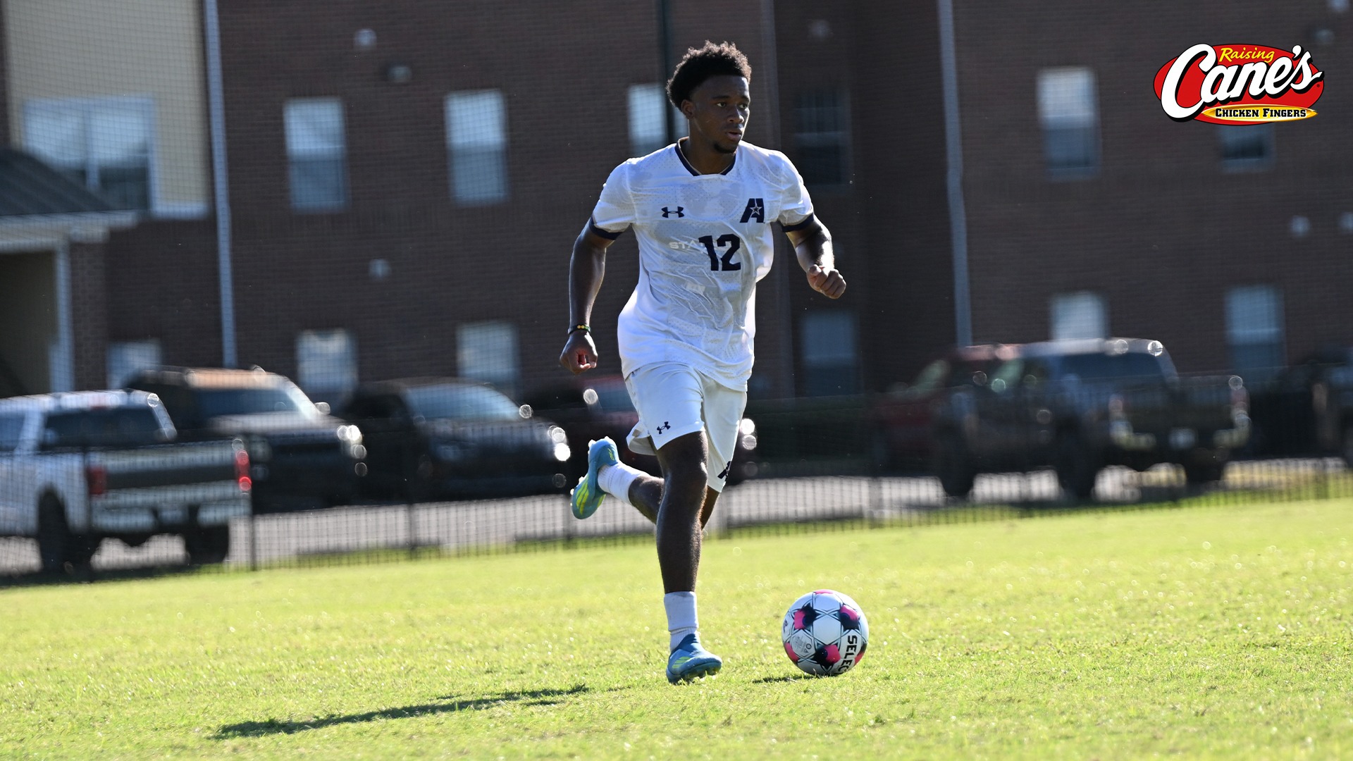 Junior Mbili dribbles in the middle of the pitch during a game
