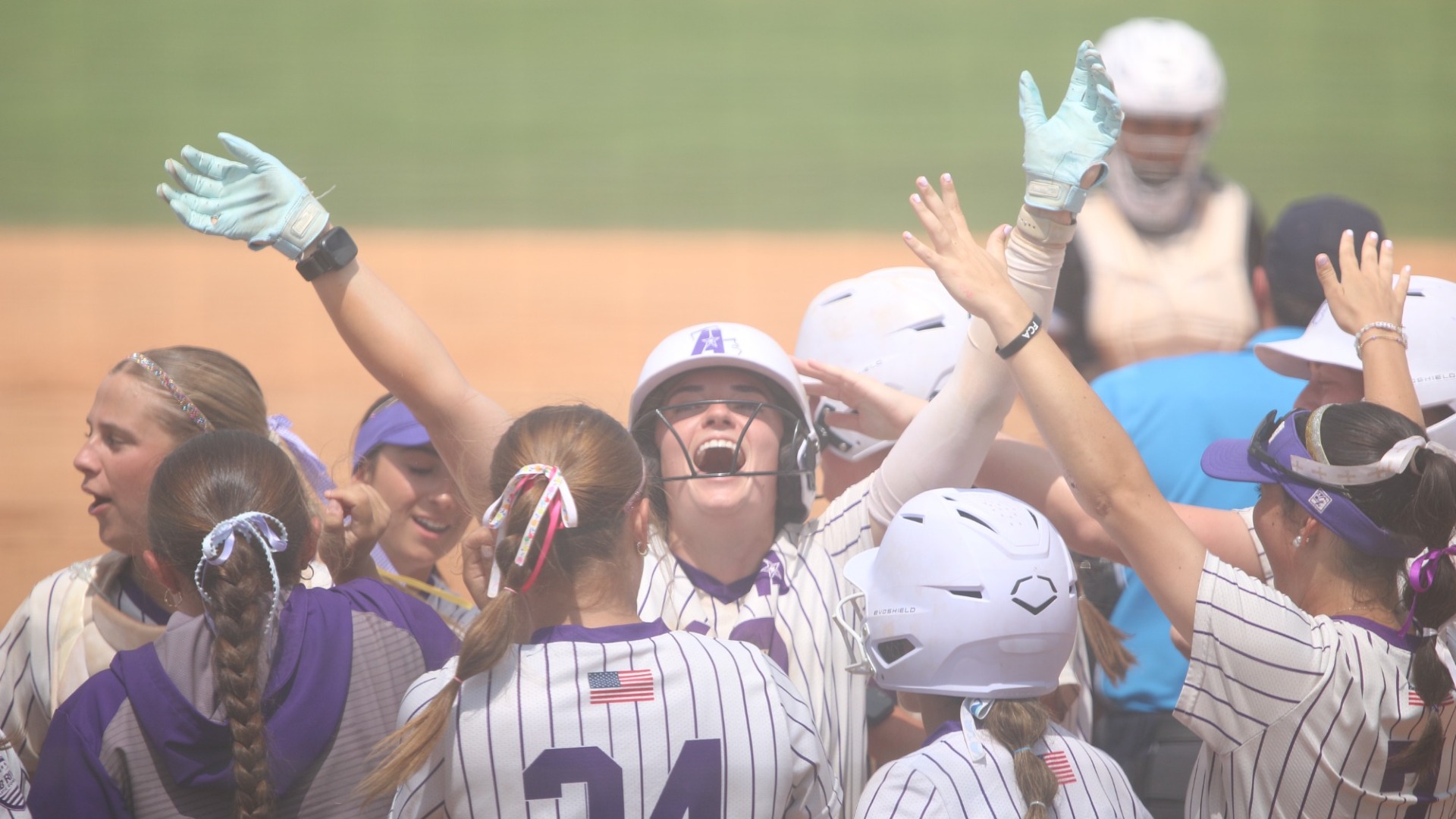 Haley Fontenot celebrates surrounded by teammates at the plate after hitting a home run
