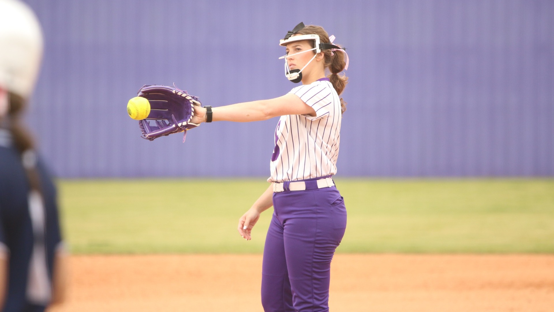 Lainee Bailey catches a throw back to her after throwing a pitch
