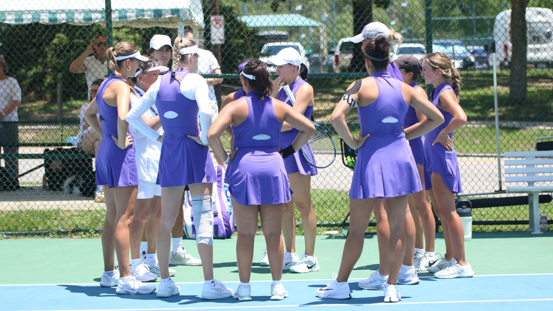 The women's tennis team huddles together before a match