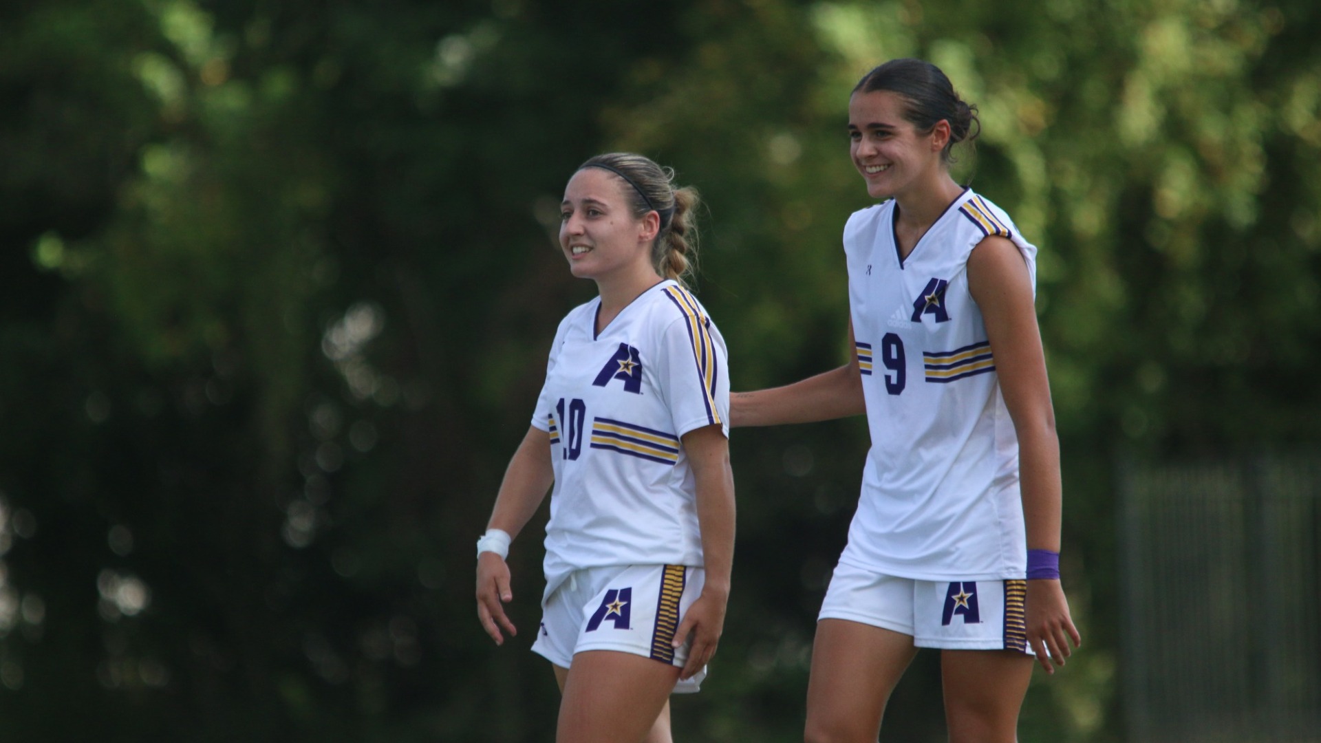 Abril Cobos celebrates with Sara Escribano after scoring against OCU