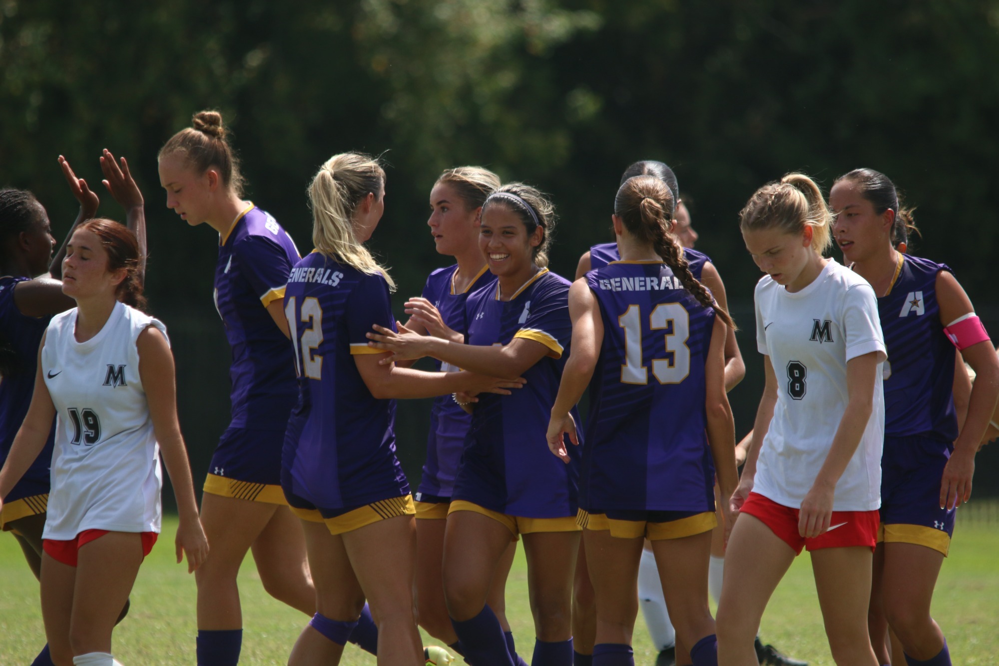 Women's Soccer players celebrate after scoring a goal late against MACU