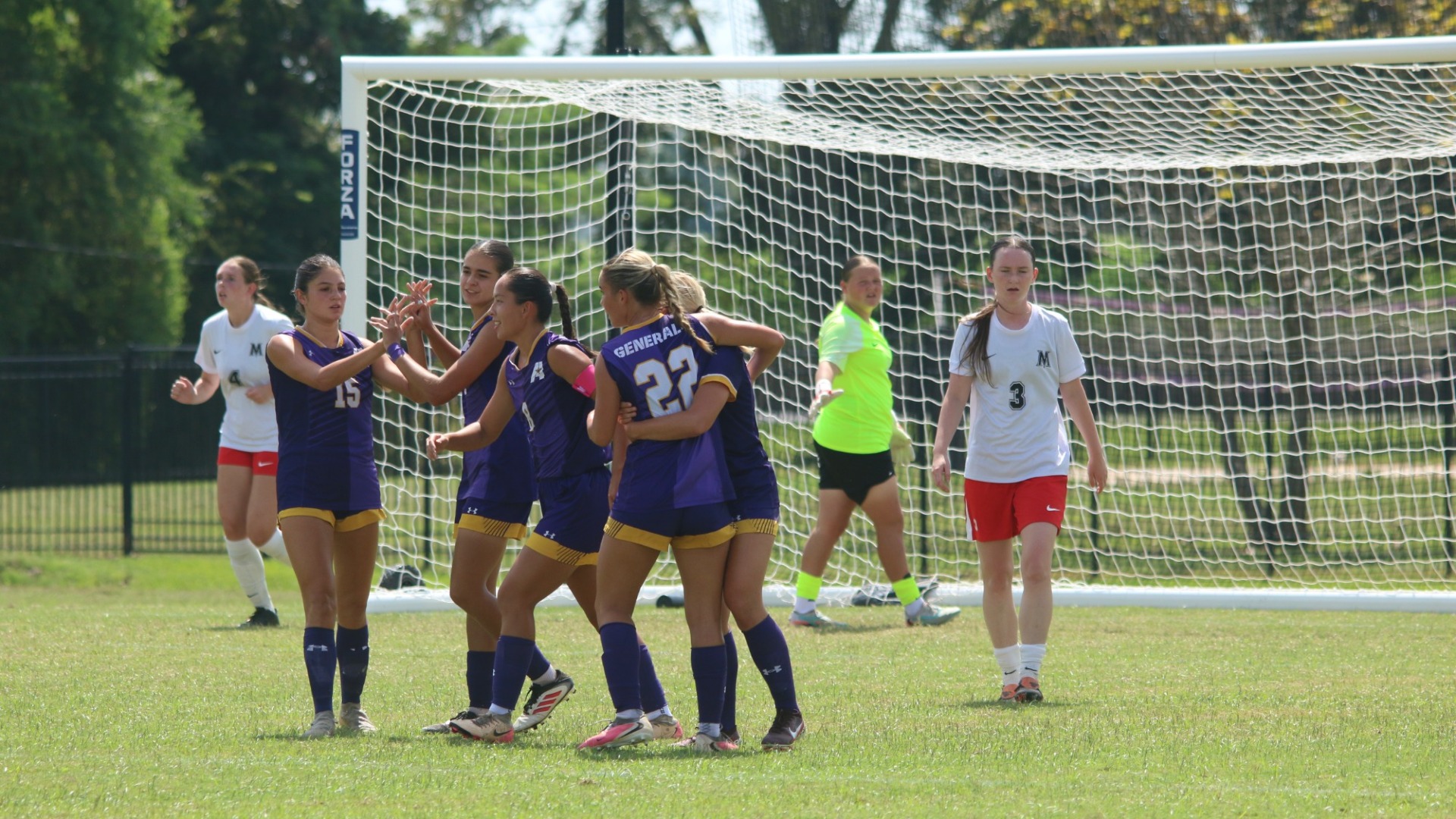 Women's Soccer players celebrate after scoring a goal