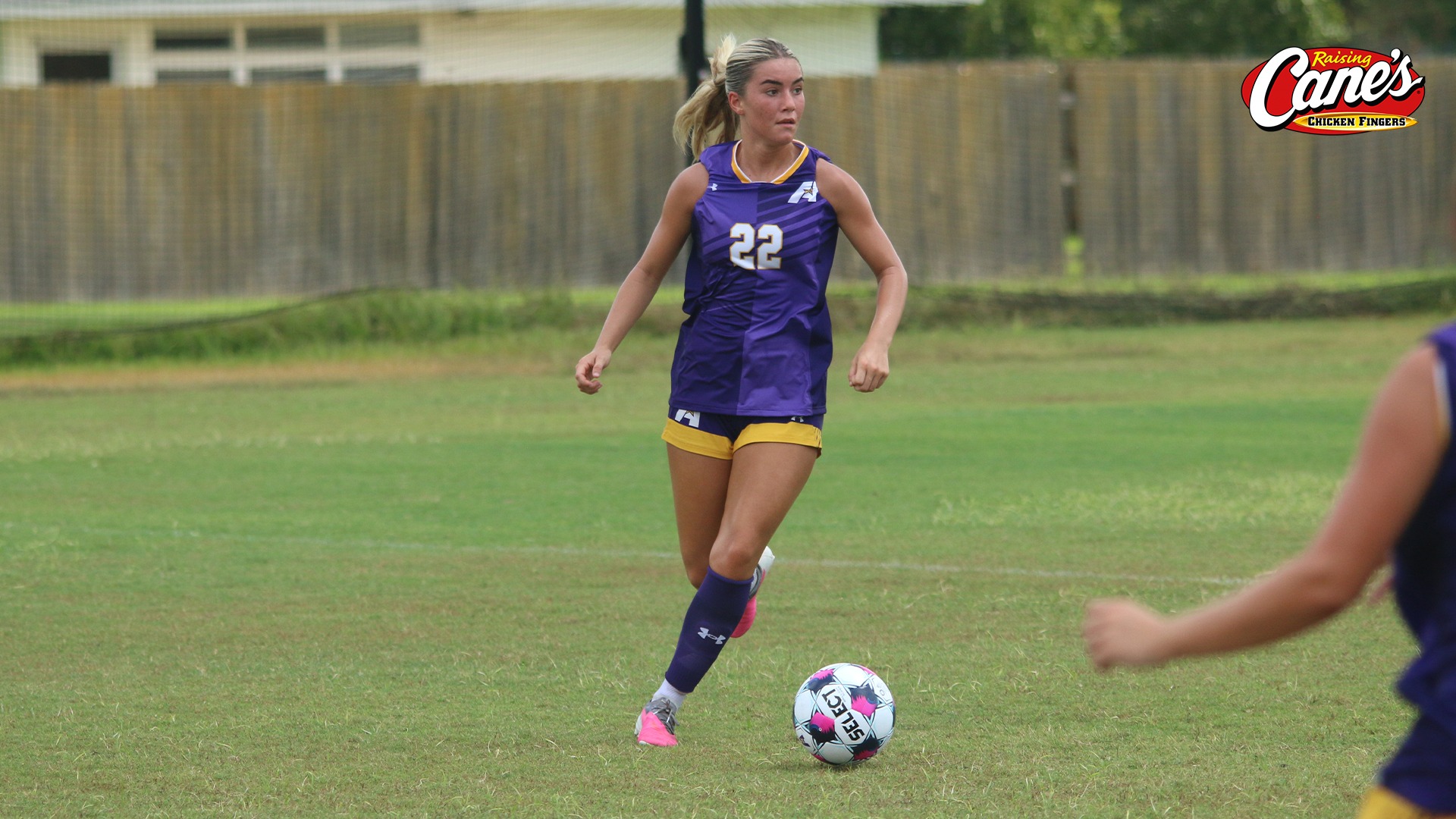 Emma Kate Rogers looks up field for a teammate while dribbling