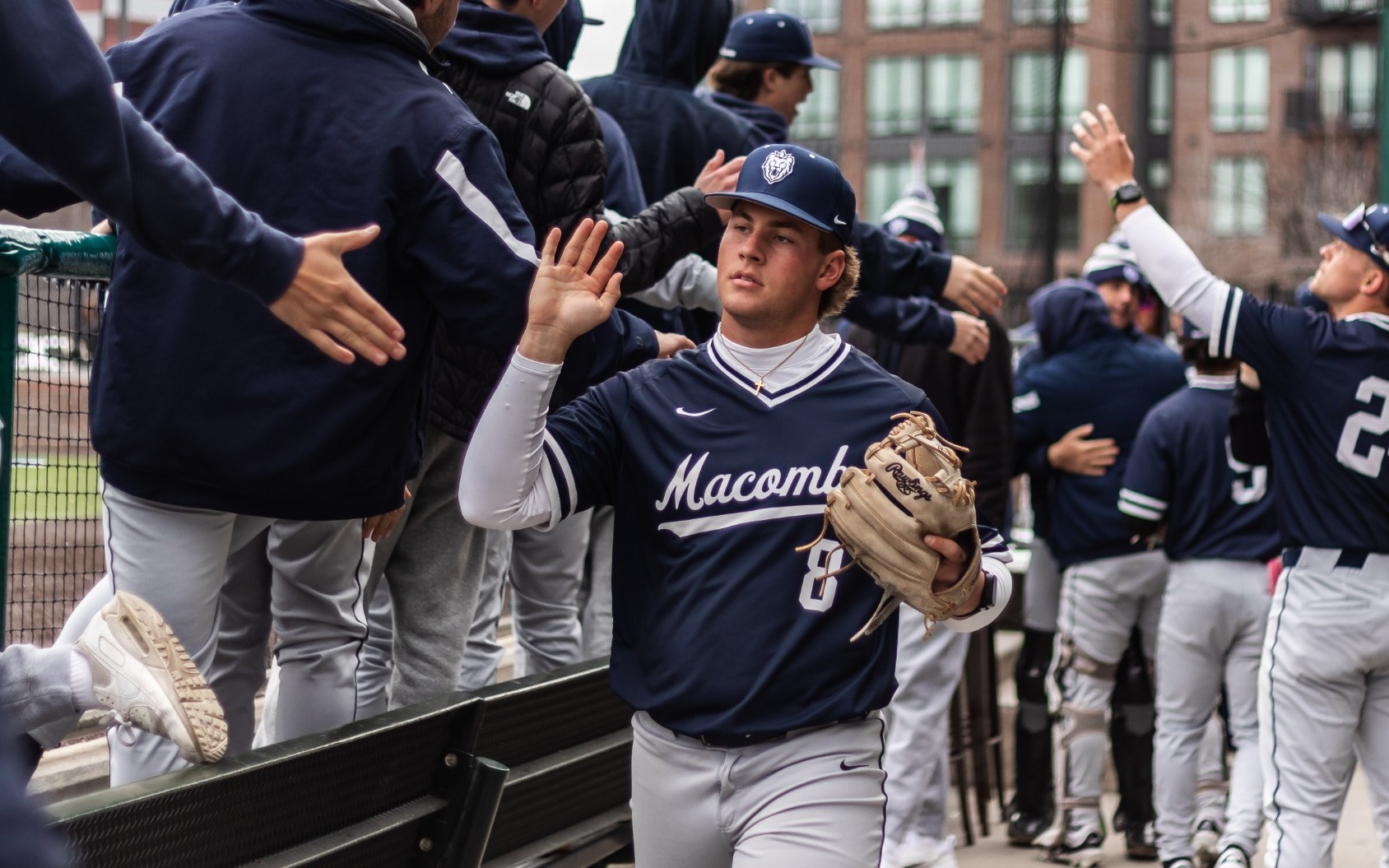 Aidan Miller (8) greets teammates in the dugout